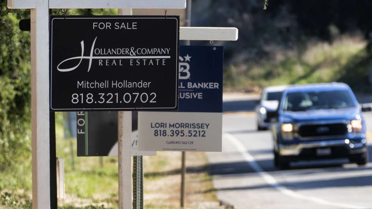Home sale signs are posted along Topanga Canyon road in Los Angeles on Oct. 19. On Tuesday, the National Association of Realtors said sales of previously occupied homes slumped in October to their slowest pace in more than 13 years.