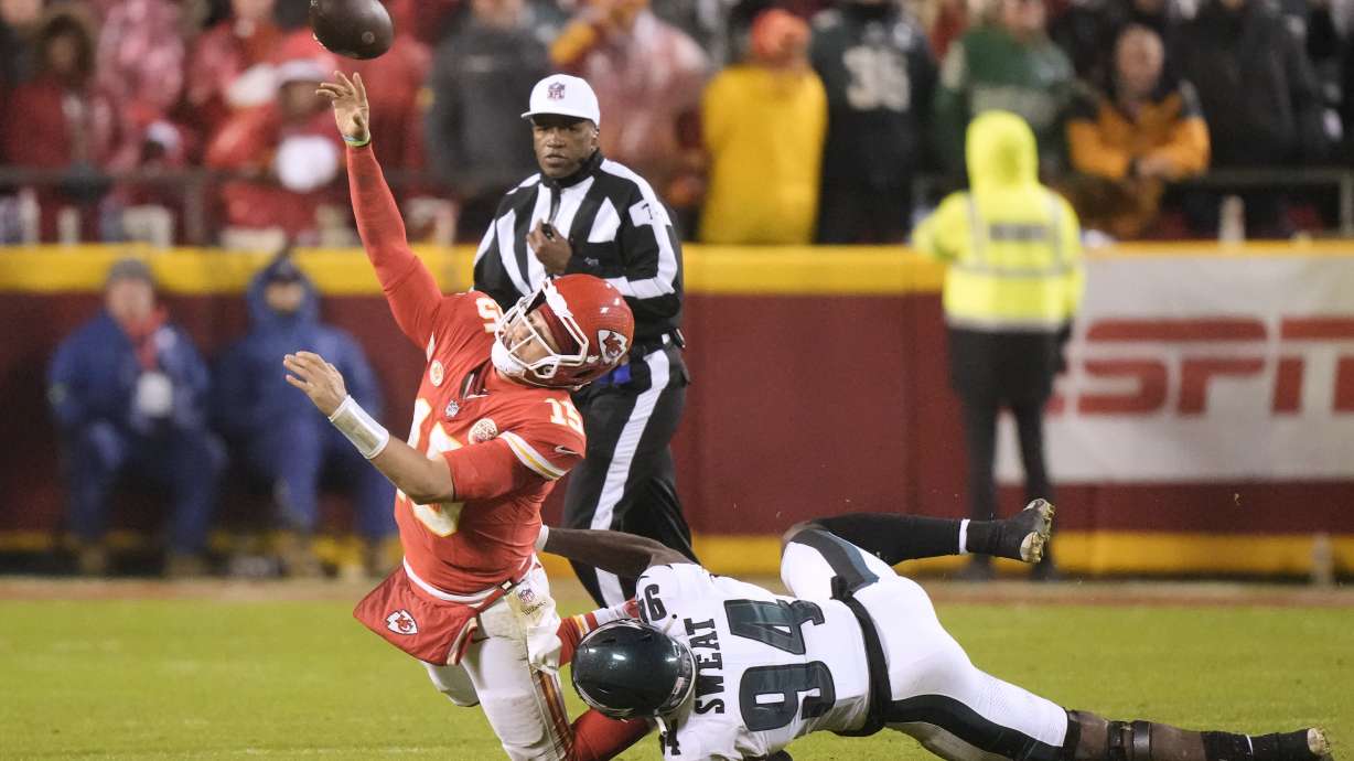 Kansas City Chiefs quarterback Patrick Mahomes, left, throws under pressure from Philadelphia Eagles defensive end Josh Sweat (94) during the second half of an NFL football game, Monday, Nov. 20, 2023, in Kansas City, Mo. Mahomes was charged with intentional grounding on the play.