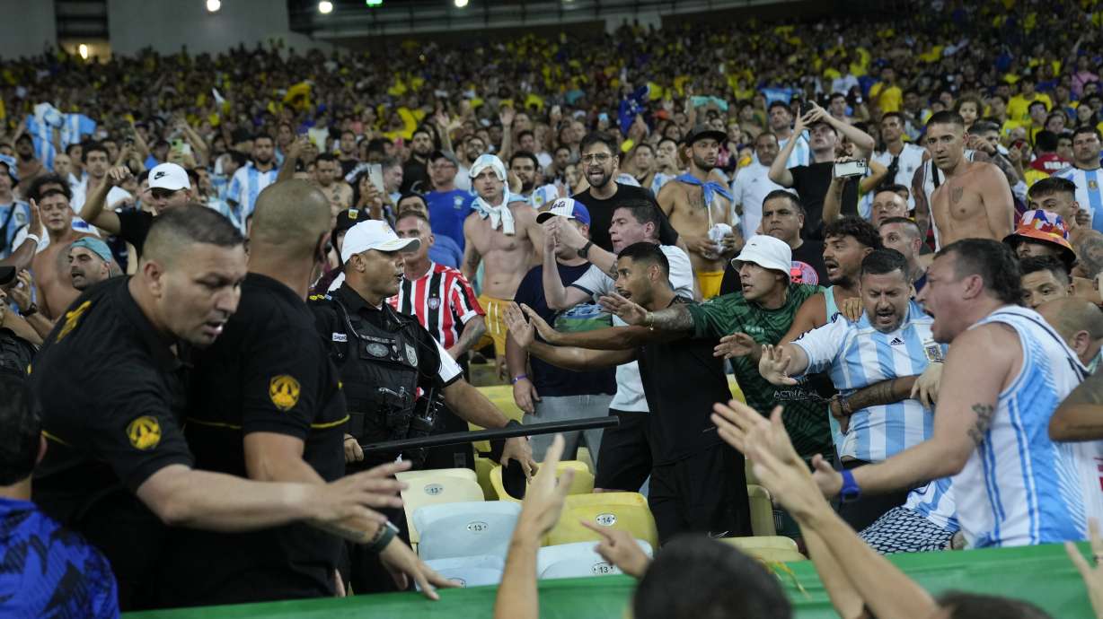 Police try to stop a fight between Brazilian and Argentina fans in the stands prior to a qualifying soccer match for the FIFA World Cup 2026 at Maracana stadium in Rio de Janeiro, Brazil, Tuesday, Nov. 21, 2023.