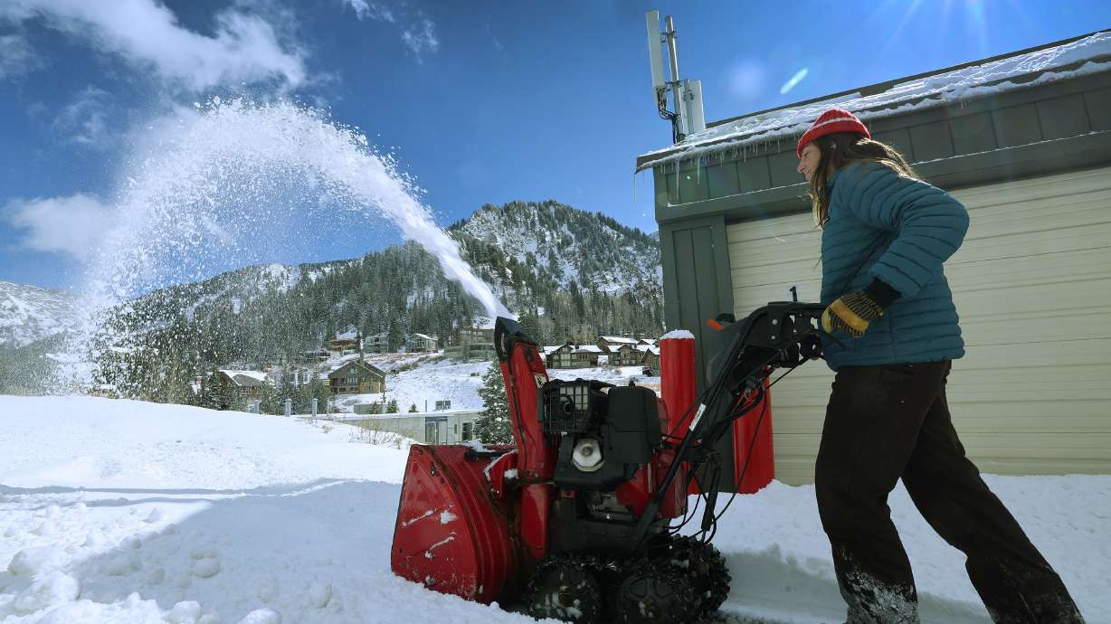 Elizabeth McDonald clears the newly fallen snow at Hellgate Condominiums in Little Cottonwood Canyon on Oct. 26. A winter storm headed toward Utah could impact some travel during the Thanksgiving weekend, especially in northern, central and eastern parts of the state.