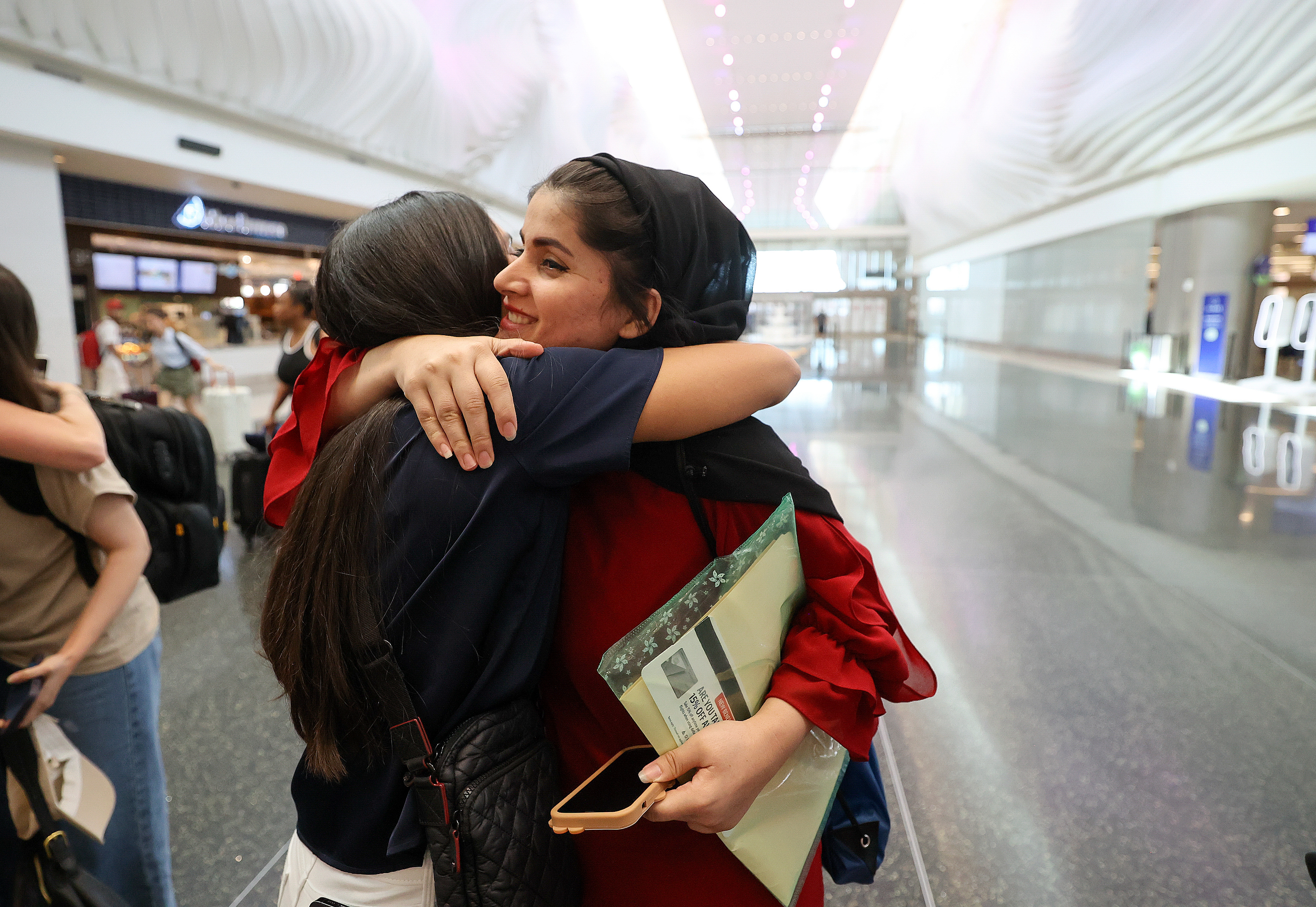 Afghan activist Crystal Bayat, left, hugs Laila Basim as Bayat welcomes five fellow activists that she helped escape from Afghanistan at the Salt Lake City International Airport in Salt Lake City on July 27. They have all been outspoken against the Taliban, advocating for women’s rights and human rights. Basim and the Crystal Bayat Foundation helped open a women’s library in Kabul, giving women and girls who are not allowed to go to school or work access to books. The library has since been shut down due to threats from the Taliban.