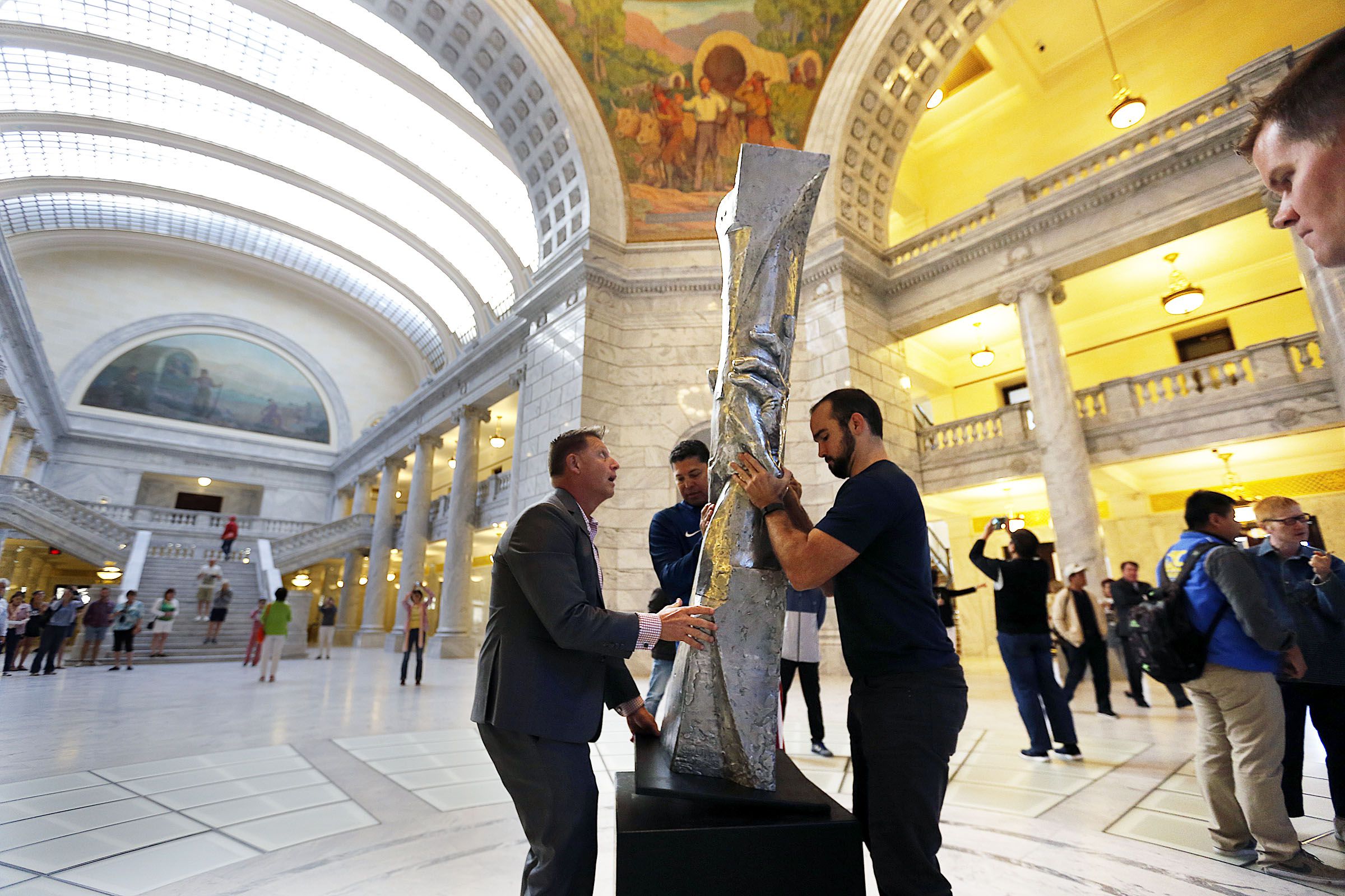 Derrin Hill, left, and David Oakes position a small replica of the Statue of Responsibility in the Utah State Capitol Rotunda in Salt Lake City on Sept. 7, 2016.