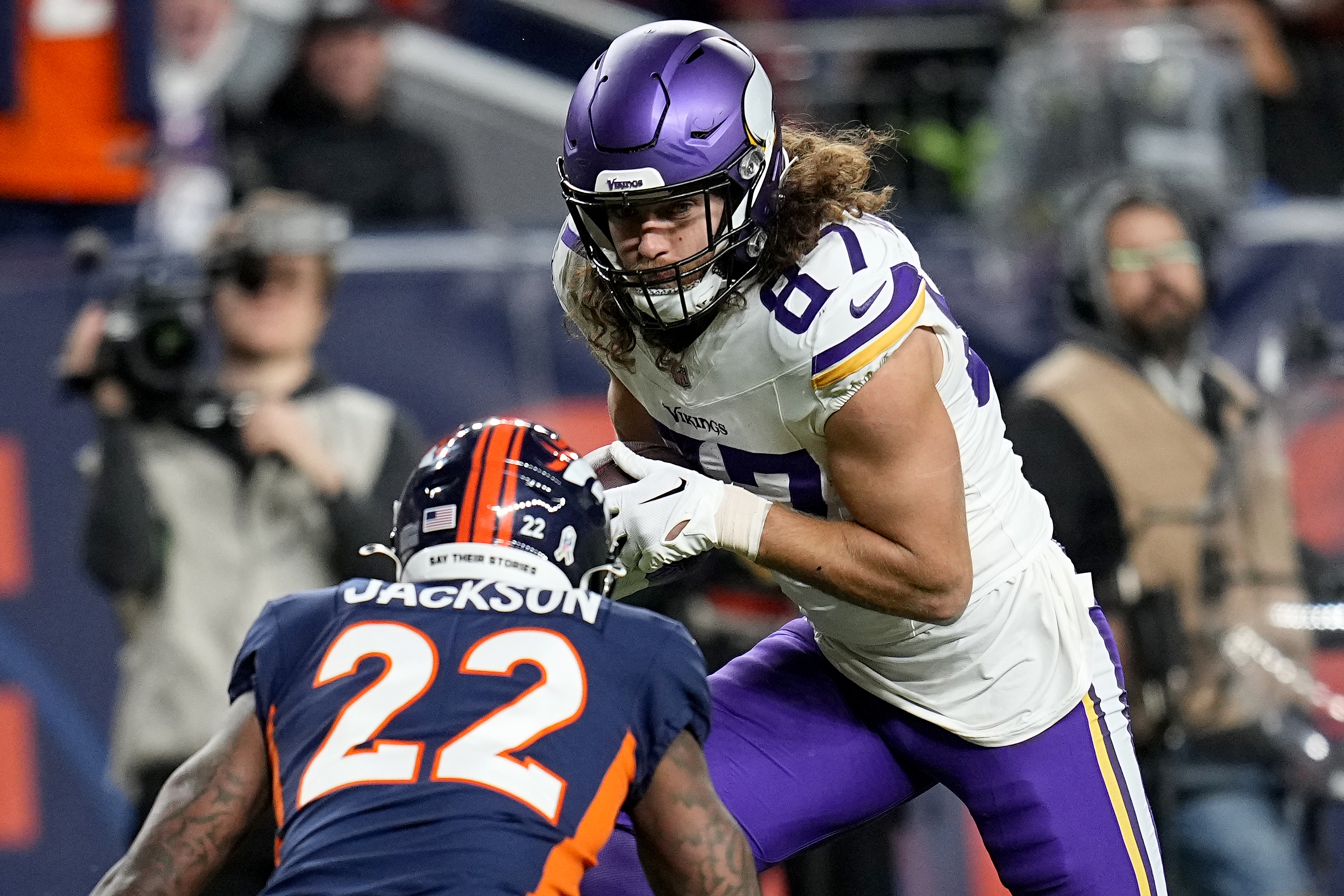 Minnesota Vikings tight end T.J. Hockenson (87) runs after the catch as Denver Broncos safety Kareem Jackson (22) defends during the first half on an NFL football game, Sunday, Nov. 19, 2023, in Denver.