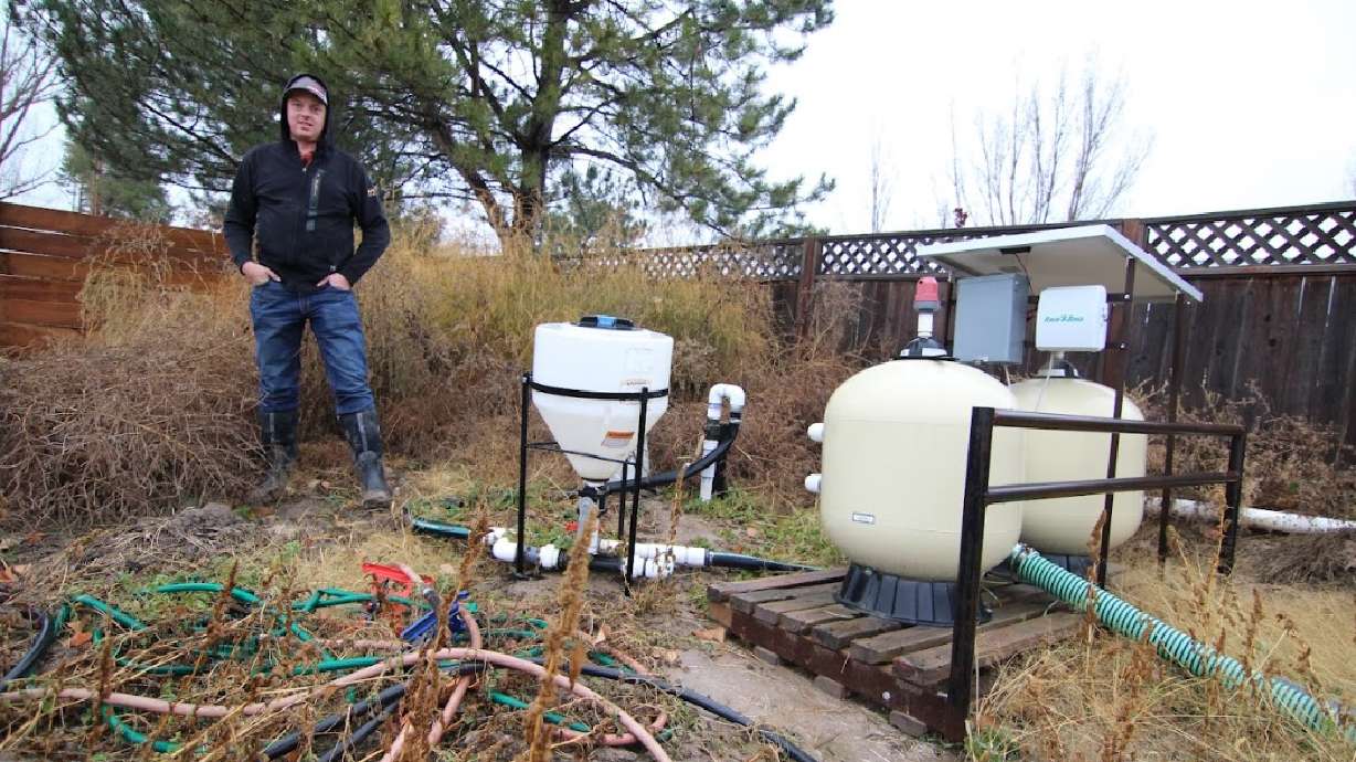 Kelby Johnson stands by equipment on his farm in Benson, Cache County. He is one of many farmers near the Great Salt Lake trying to balance work and the future of the lake.