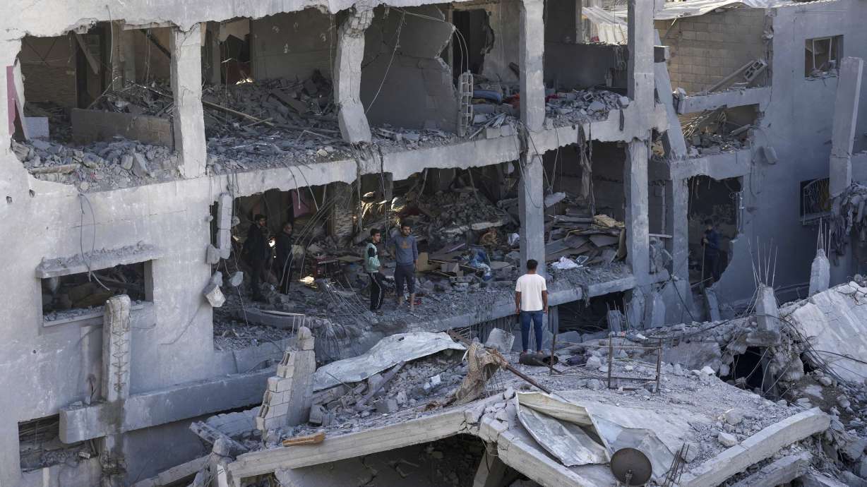Palestinians inspect the rubble of destroyed building of Muharib family killed in the Israeli bombardment of the Gaza Strip in Nusseirat refugee camp, central Gaza Strip, Thursday.