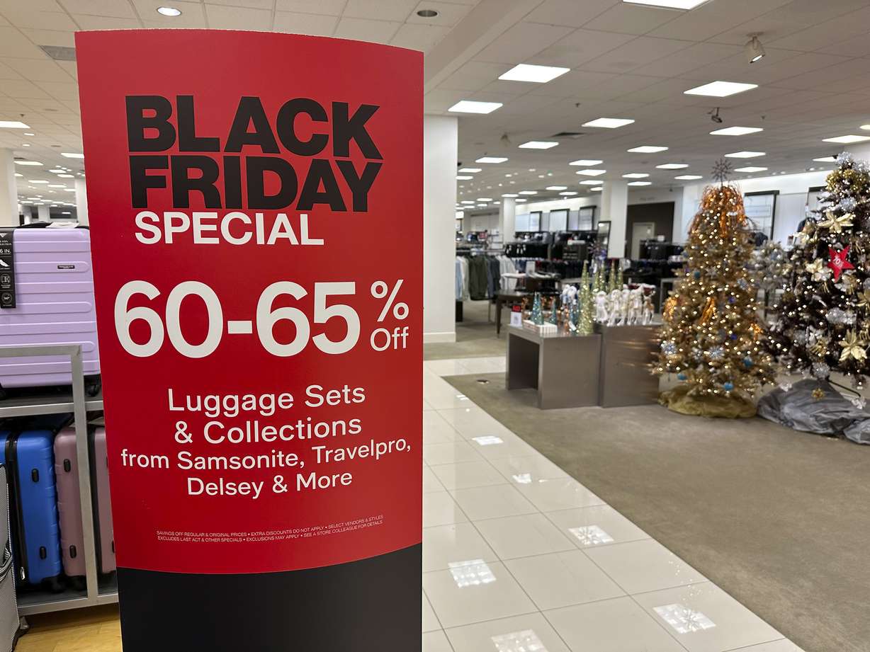 A sign announces Black Friday specials on luggage sets inside a Macy's department store on Nov. 20, in Denver. Retailers are kicking off the unofficial start of the holiday shopping season on Friday with a bevy of discounts and other enticements.