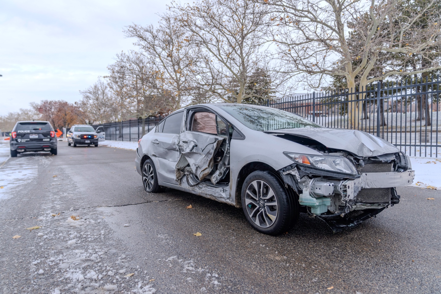 Police say the driver of this Honda Civic crashed into two parked cars and then drove away before crashing through a fence at a veterans hospital in Salt Lake City on Friday.