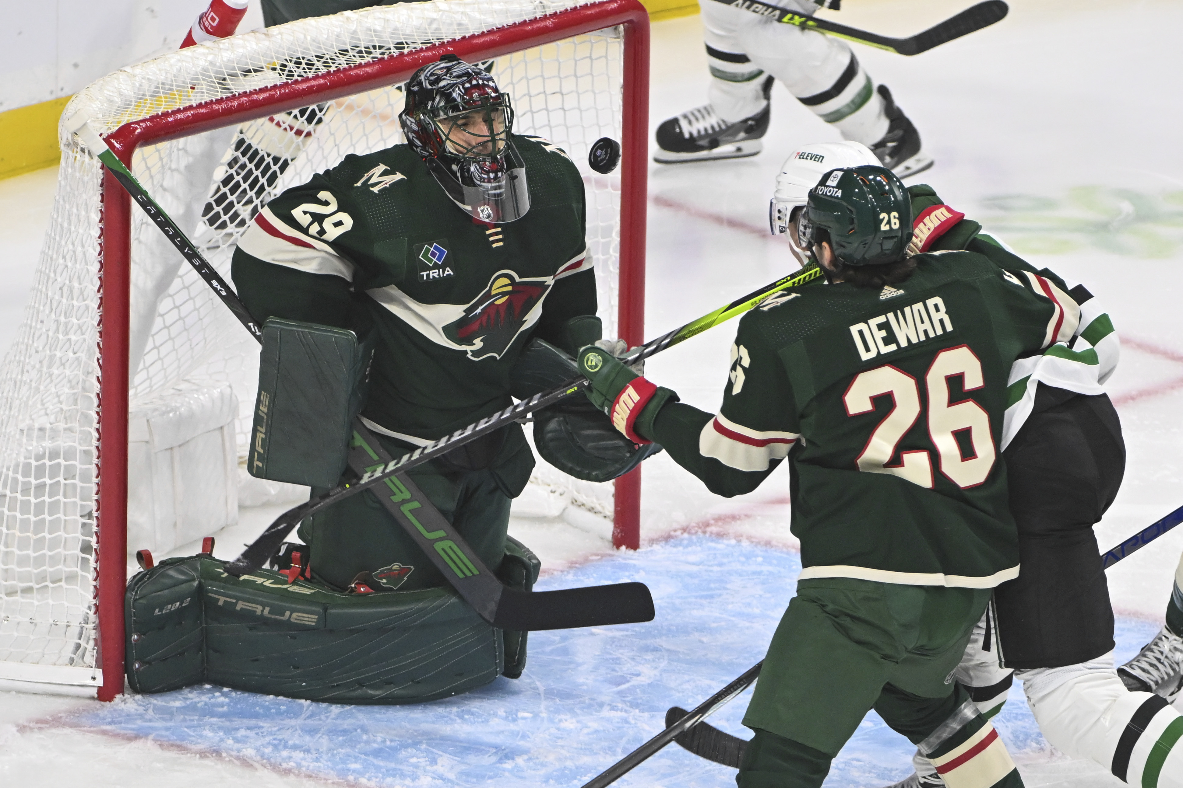 Minnesota Wild goalie Marc-Andre Fleury (29) blocks a shot by Dallas Stars center Radek Faksa, back right, as Wild center Connor Dewar tries to clear Faska from the goal during the first period of an NHL hockey game Sunday, Nov. 12, 2023, in St. Paul, Minn. 