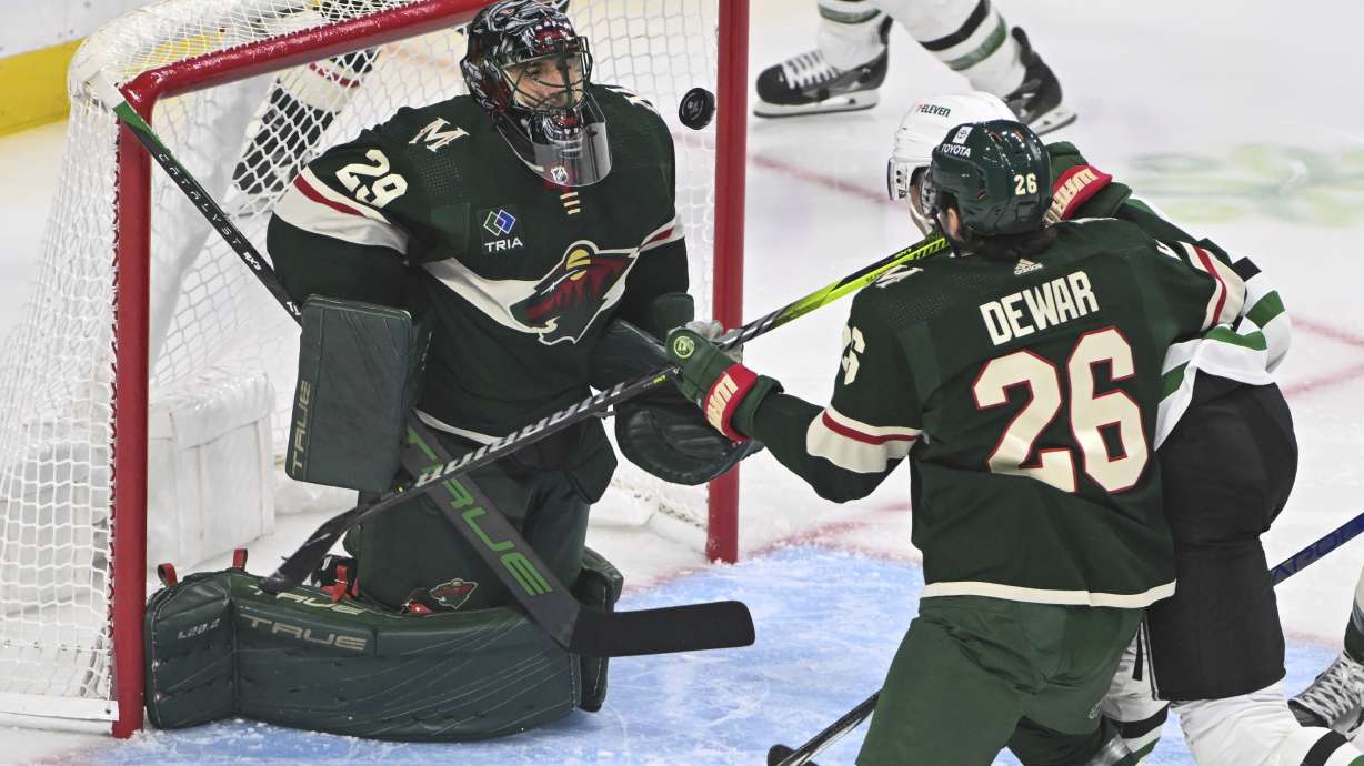 Minnesota Wild goalie Marc-Andre Fleury (29) blocks a shot by Dallas Stars center Radek Faksa, back right, as Wild center Connor Dewar tries to clear Faska from the goal during the first period of an NHL hockey game Sunday, Nov. 12, 2023, in St. Paul, Minn.
