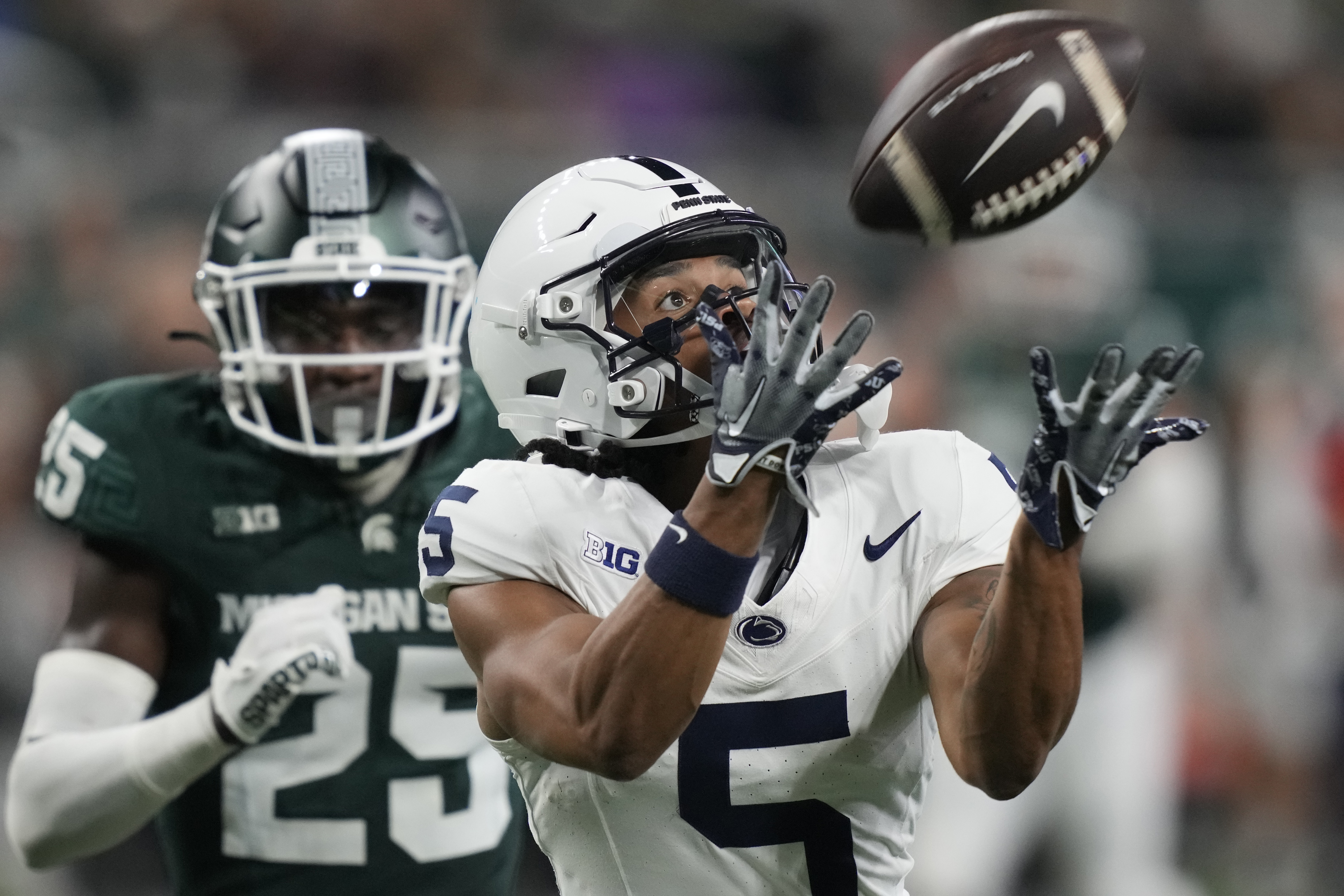 Penn State wide receiver Omari Evans (5), defended by Michigan State defensive back Chance Rucker (25), catches a pass to set up a touchdown during the second half of an NCAA college football game, Friday, Nov. 24, 2023, in Detroit.