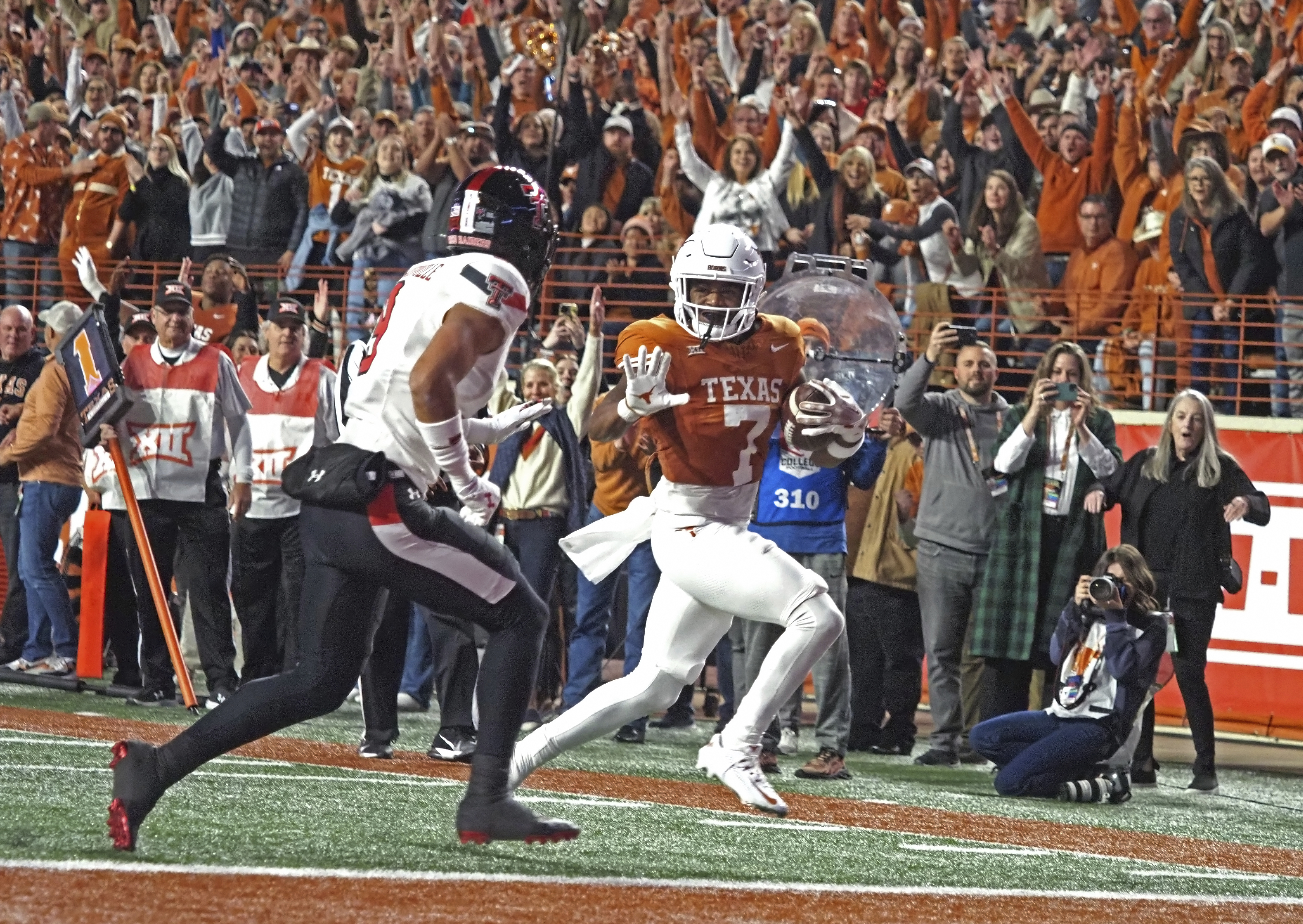 Texas running back Keilan Robinson (7) runs for a touchdown against Texas Tech defensive back C.J. Baskerville, left, during the first half of an NCAA college football game, Friday, Nov. 24, 2023, in Austin, Texas.