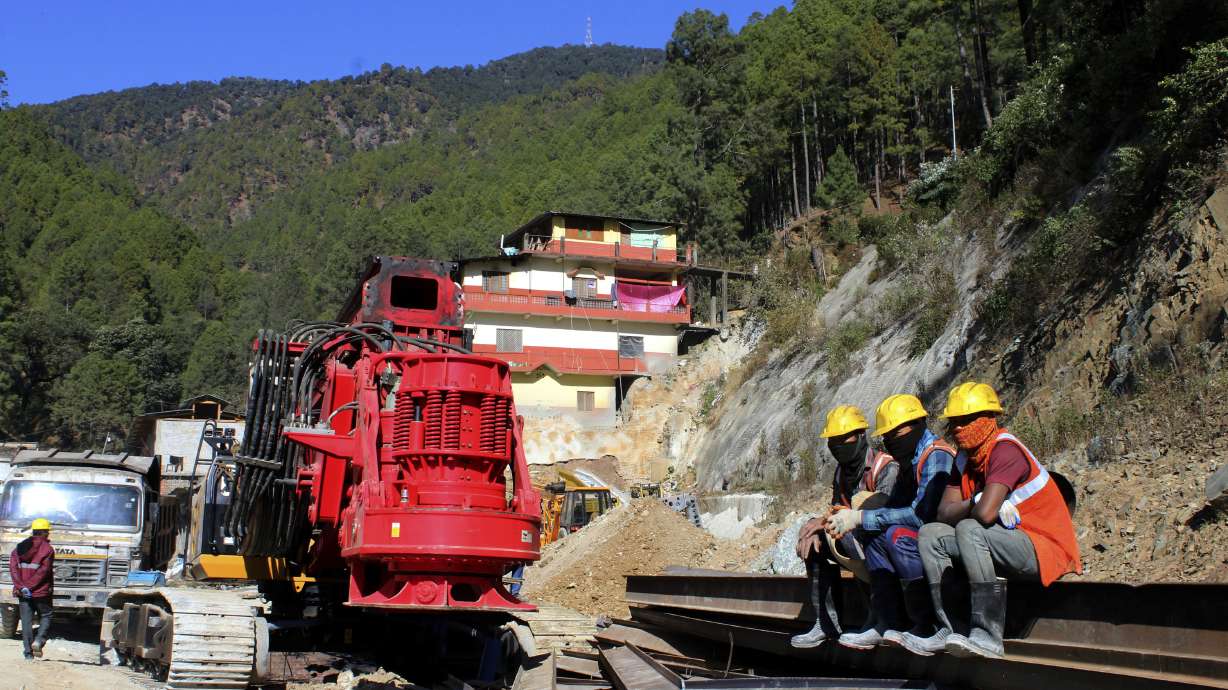 Rescuers rest at the site of an under-construction road tunnel that collapsed in Silkyara in the northern Indian state of Uttarakhand, Friday. Rescuers are racing to evacuate 41 construction workers who have been trapped for nearly two weeks.