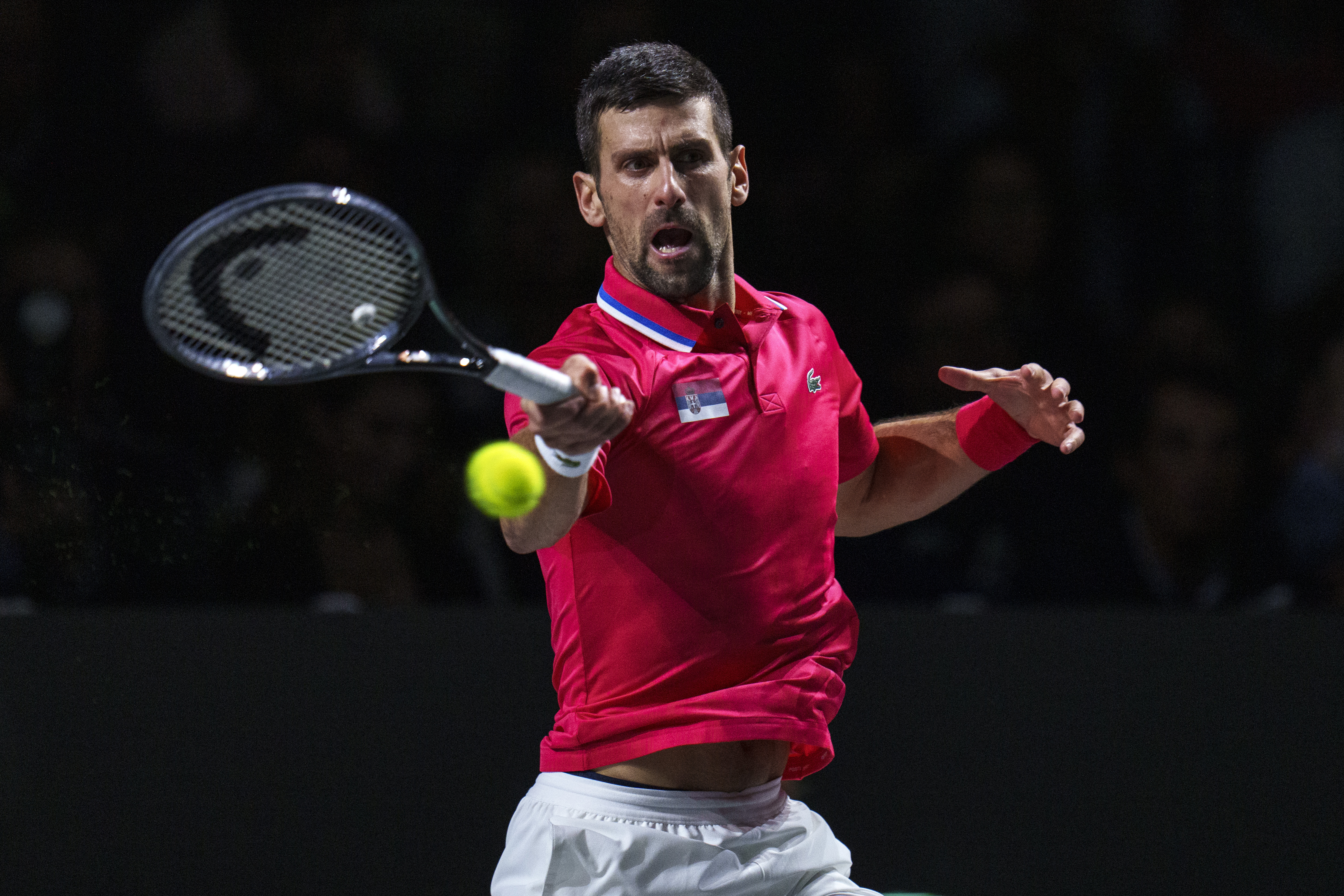 Novak Djokovic of Serbia returns the ball against Jannik Sinner of Italy during a Davis Cup semi-final tennis match between Italy and Serbia in Malaga, Spain, Saturday, Nov. 25, 2023.