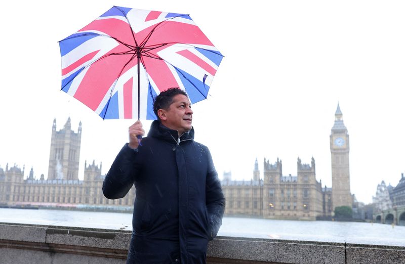 Italian chef-turned restaurant owner Francesco Mazzei shields from the rain as he poses for a portrait near the Houses of Parliament in London, Britain, Nov. 14.