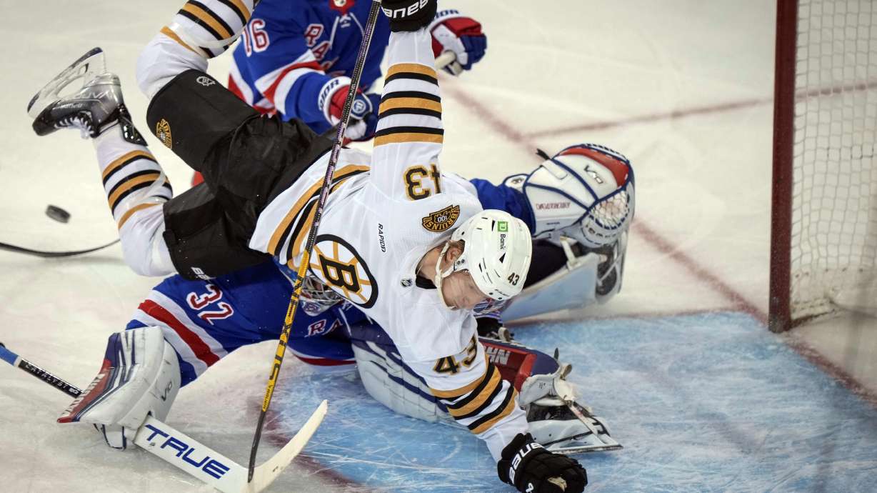 Boston Bruins Danton Heinen collides with New York Rangers goaltender Jonathan Quick (32) during the second period an NHL hockey game, Saturday, Nov. 25, 2023, in New York.