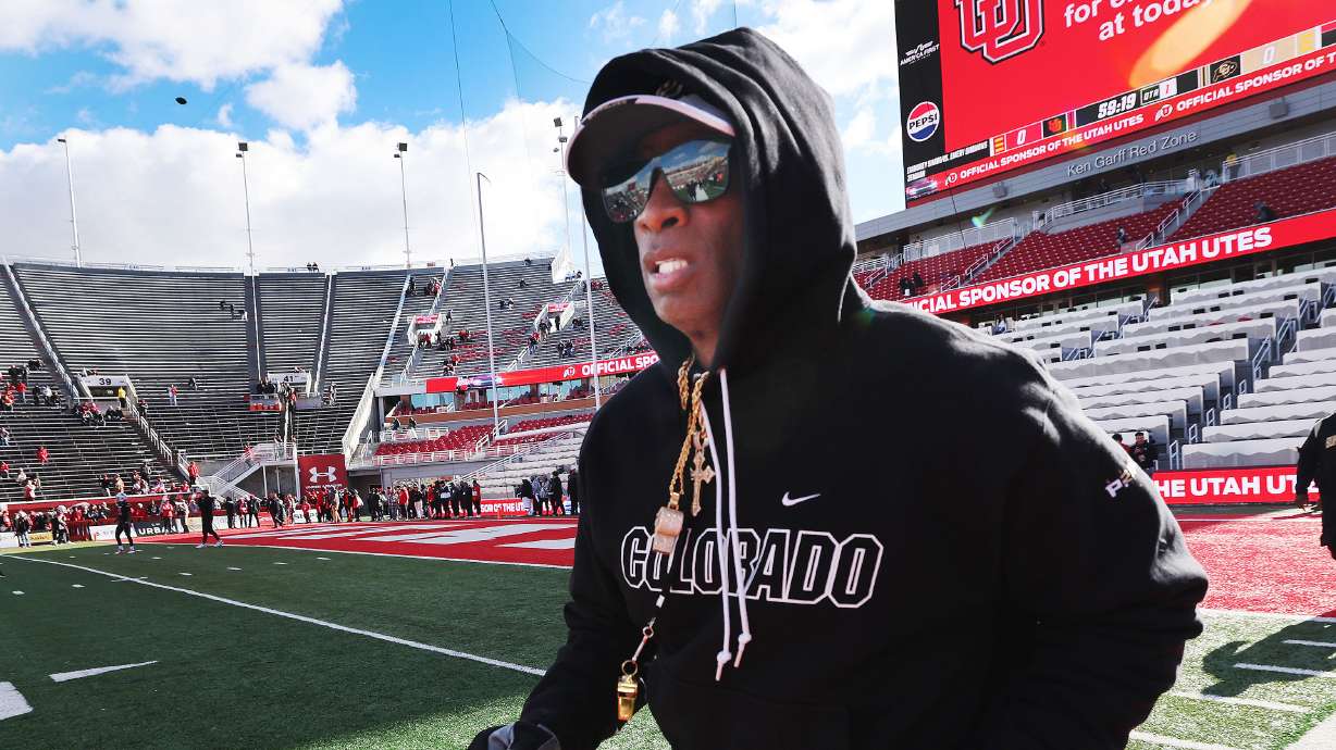 Colorado Buffaloes head coach Deion Sanders runs onto the field in Salt Lake City on Saturday, Nov. 25, 2023.