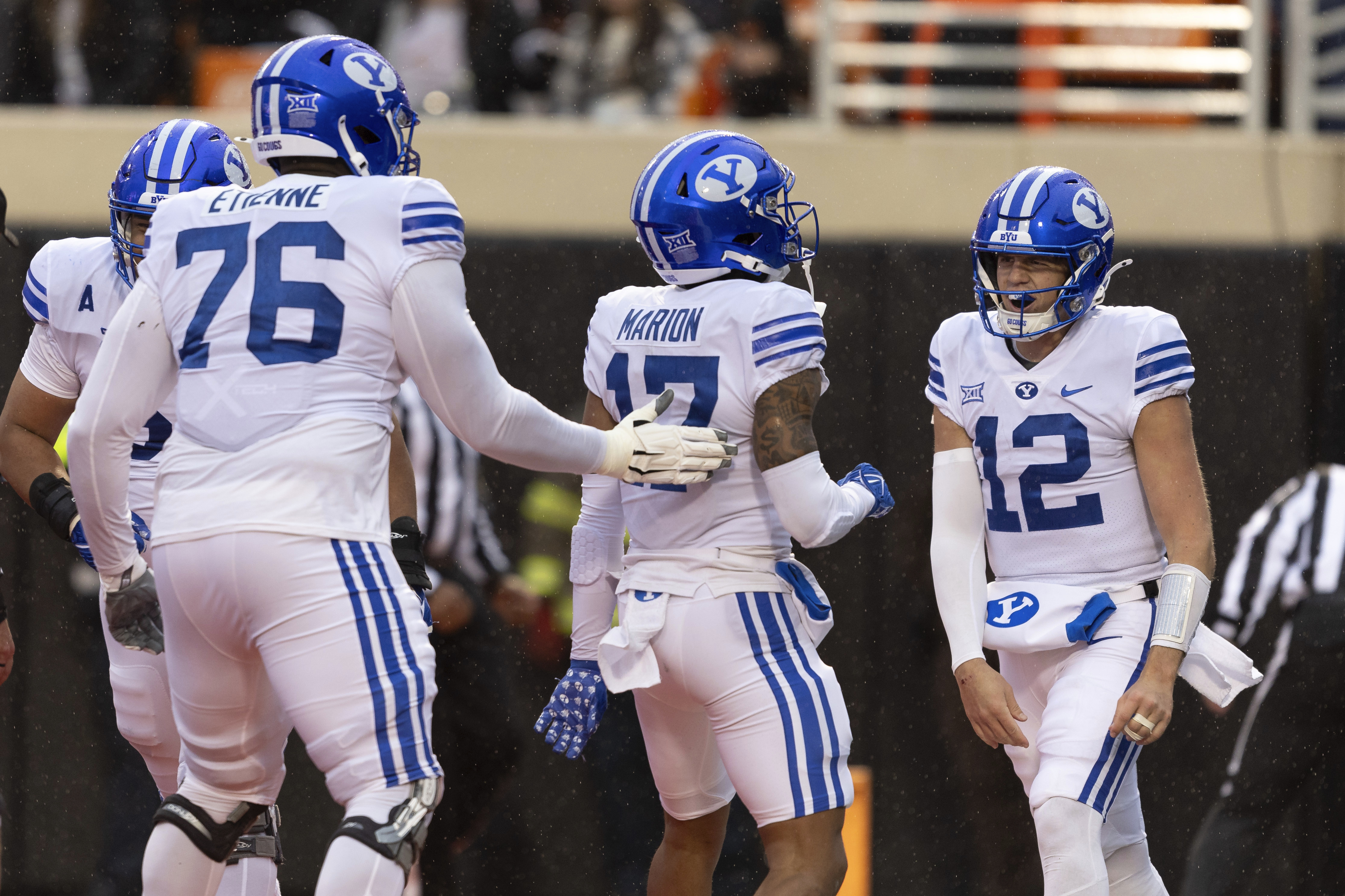 BYU quarterback Jake Retzlaff (12) and offensive lineman Caleb Etienne (76) celebrate with wide receiver Keelan Marion (17) after he scores a touchdown in the first half of an NCAA college football game against Oklahoma State Saturday, Nov. 25, 2023, in Stillwater, Okla.