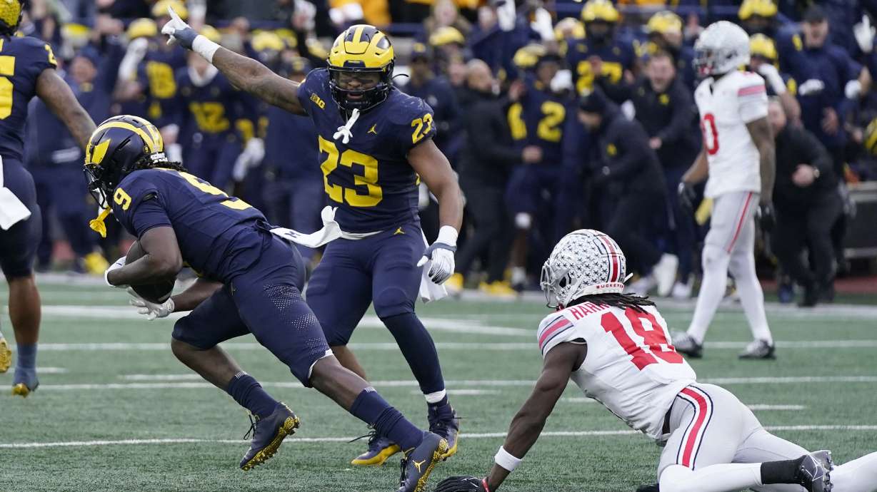 Michigan defensive back Rod Moore (9) intercepts a pass intended for Ohio State wide receiver Marvin Harrison Jr. (18) during the second half of an NCAA college football game, Saturday, Nov. 25, 2023, in Ann Arbor, Mich.