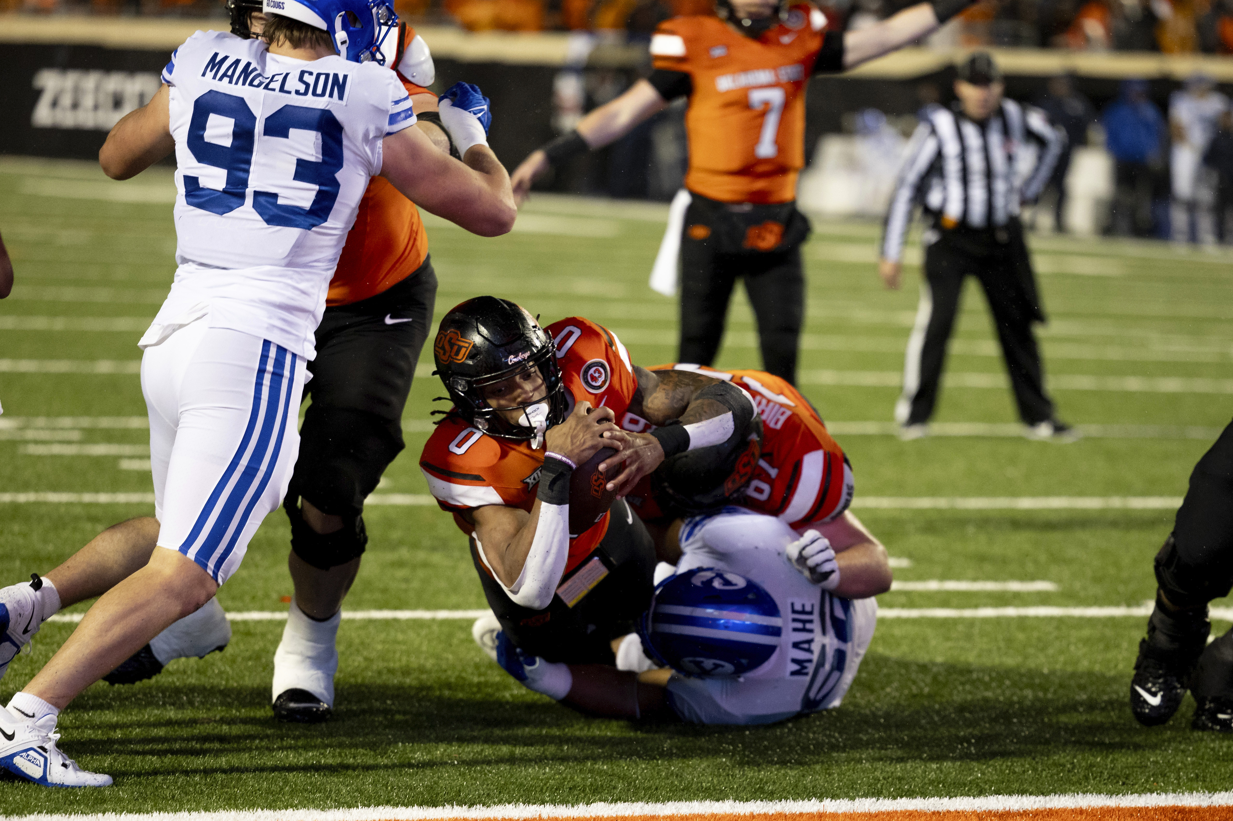 Oklahoma State running back Ollie Gordon II (0) dives over BYU defensive tackle Atunaisa Mahe (62) for a touchdown in the second half of an NCAA college football game Saturday, Nov. 25, 2023, in Stillwater, Okla.