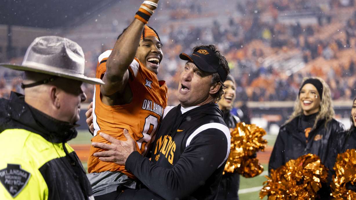 Oklahoma State wide receiver Brennan Presley (80) celebrates in the arms of Oklahoma State coach Mike Gundy arms after an NCAA college football game against BYU on Saturday, Nov. 25, 2023, in Stillwater, Okla.