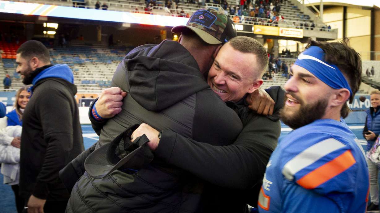 Boise State interim coach Spencer Danielson hugs a member of the coaching staff following the team's win over Air Force in an NCAA college football game Friday, Nov. 24, 2023, in Boise, Idaho.