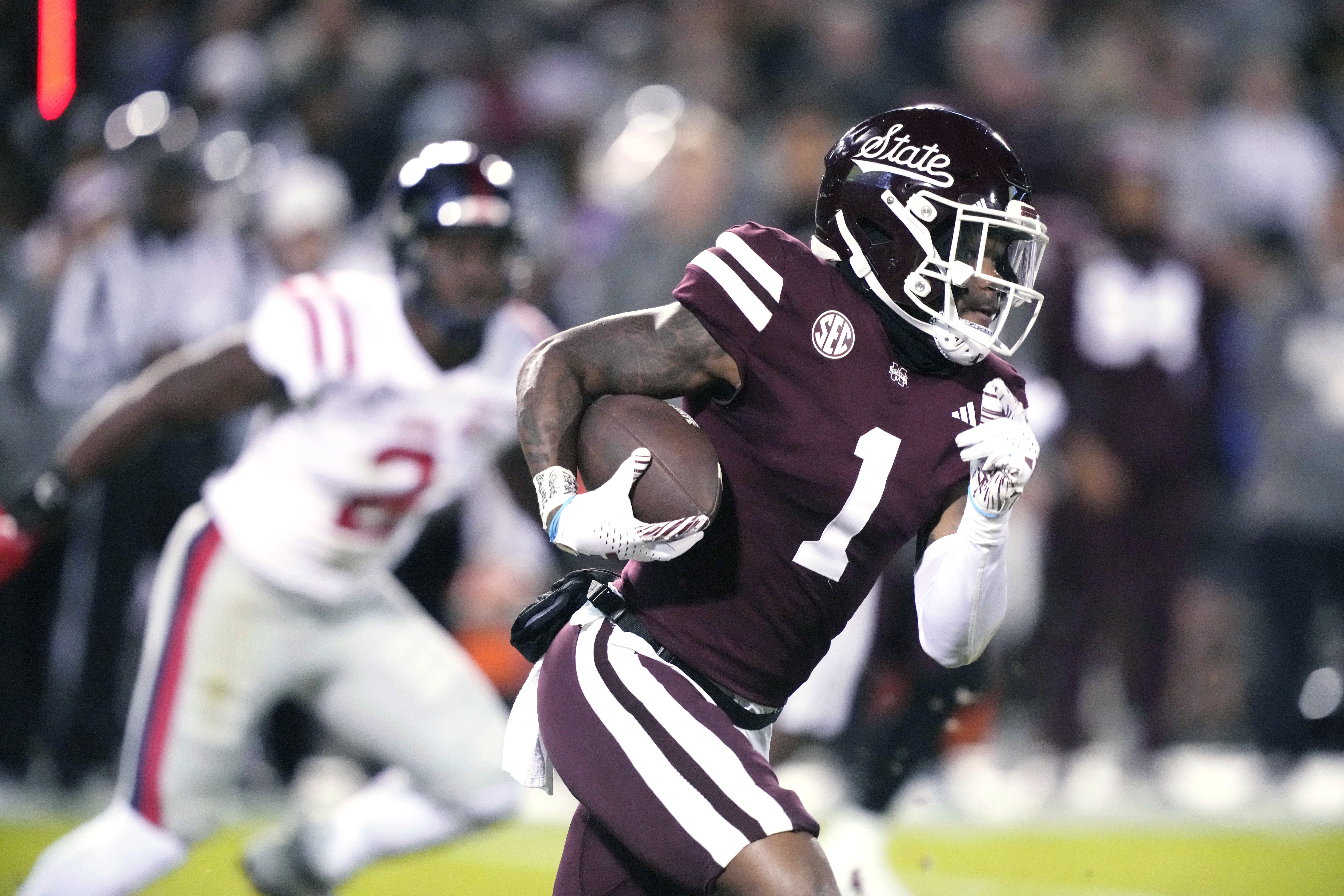 Mississippi State wide receiver Zavion Thomas (1) runs for a first down while being pursued by a Mississippi defender during the first half of an NCAA college football game in Starkville, Miss., Thursday, Nov. 23, 2023.