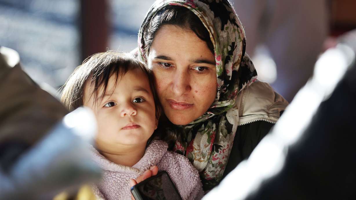 Anisa Alamgir holds her daughter Zenattunlsa while waiting for food as Mosaic Inter-Faith Ministries hands out Thanksgiving meals in Salt Lake City on Nov. 21.