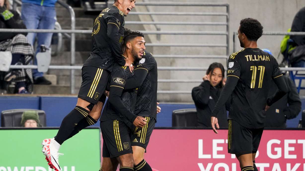 Los Angeles FC forward Cristian Olivera, left, jumps to celebrate with forward Denis Bouanga, second from left, and midfielder Timothy Tillman (11) after Bouanga scored against the Seattle Sounders during the first half of an MLS conference semifinal playoff soccer match Sunday, Nov. 26, 2023, in Seattle.
