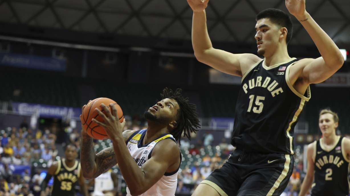 Marquette forward David Joplin tries to shoot over Purdue center Zach Edey (15) during the first half of an NCAA college basketball game, Wednesday, Nov. 22, 2023, in Honolulu.