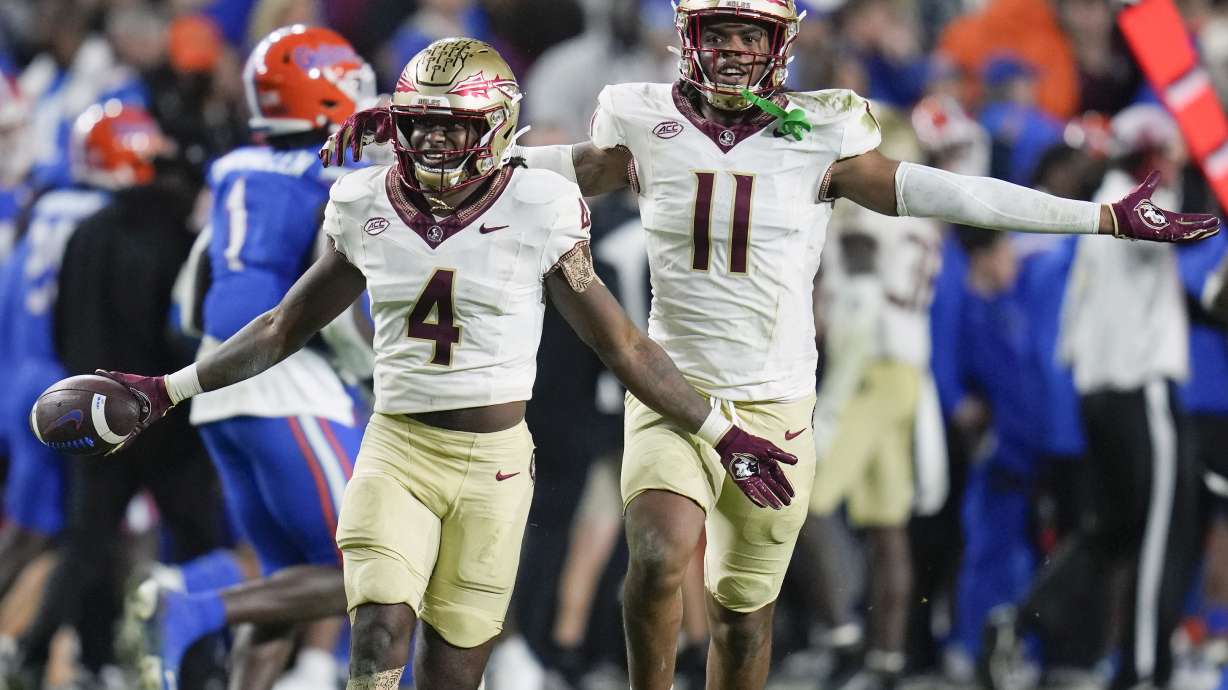 Florida State linebacker Kalen DeLoach (4) celebrates with defensive lineman Patrick Payton (11) after he intercepted a Florida pass late in the second half of an NCAA college football game Saturday, Nov. 25, 2023, in Gainesville, Fla.