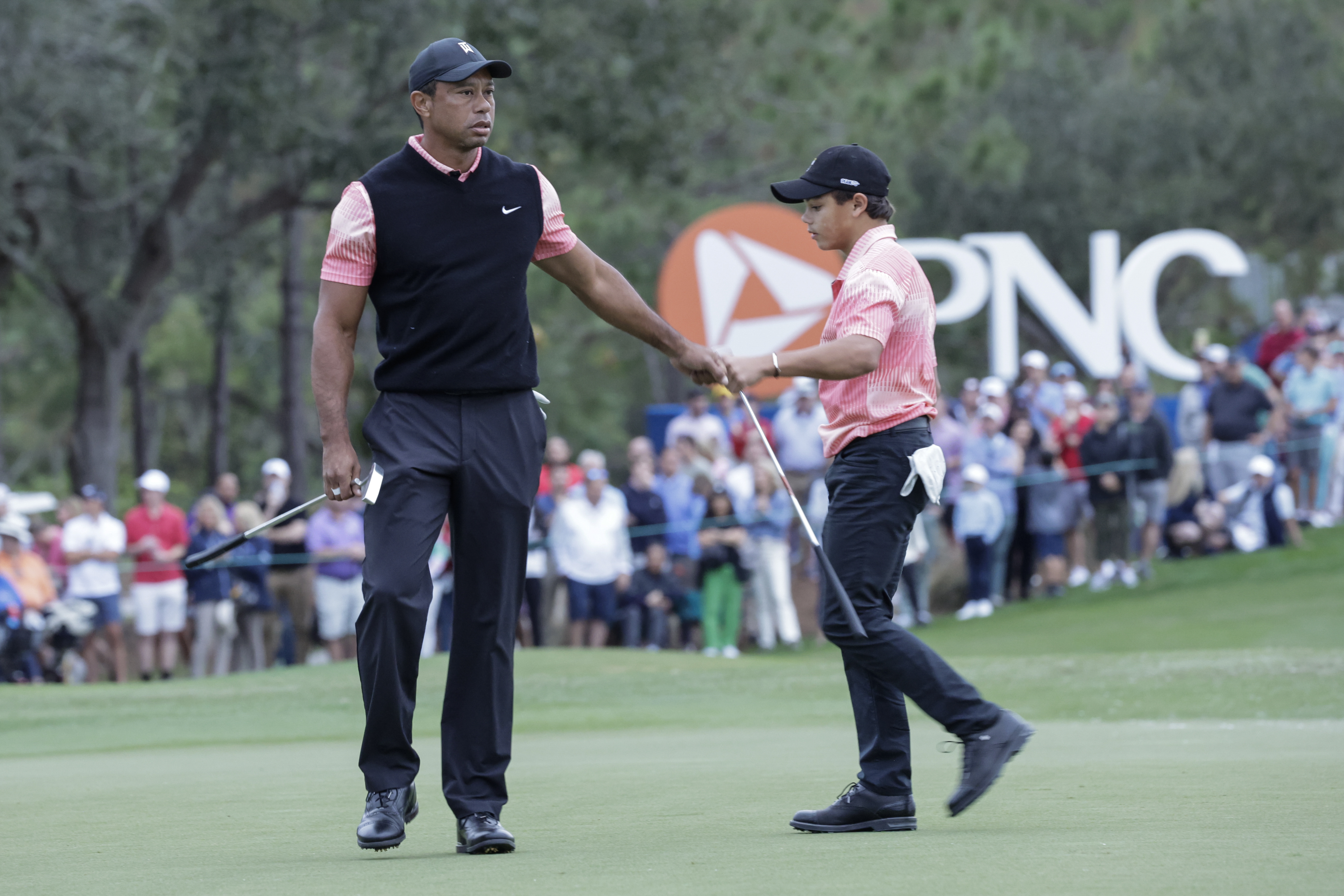 FILE - Tiger Woods, left, congratulates his son Charlie Woods, right, after finishing the 18th hole during the first round of the PNC Championship golf tournament Saturday, Dec. 17, 2022, in Orlando, Fla. Woods and his son are returning to play in this year's tournament for the fourth straight year.