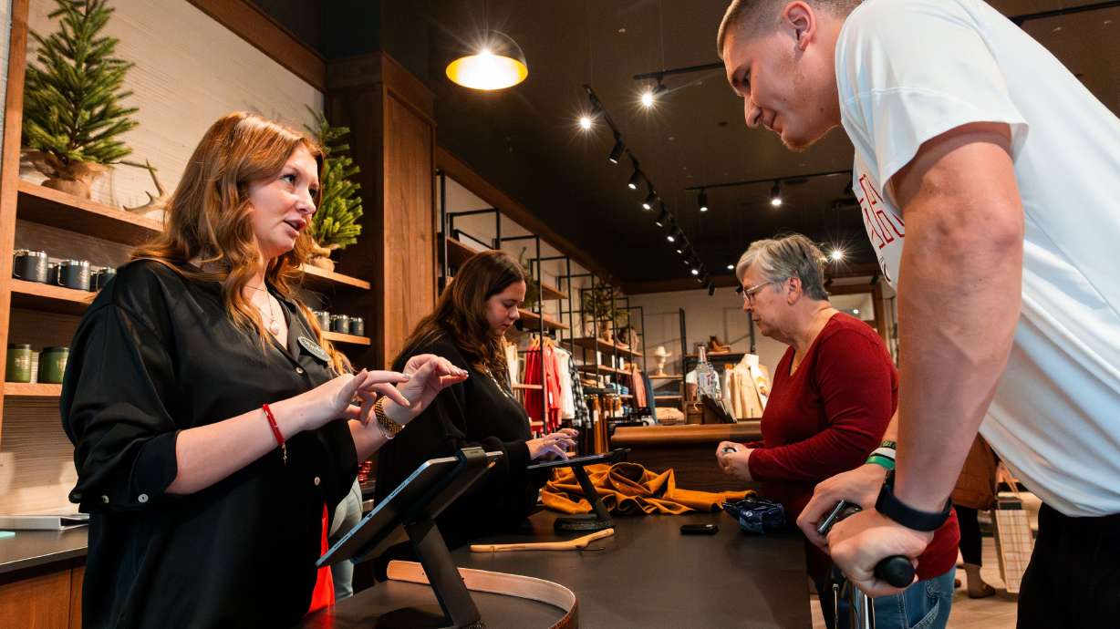 Sydney Vanderheiden checks out Lander Barton on Black Friday at Tecovas at City Creek Center in Salt Lake City on Nov. 24. U.S. consumers spent at record levels over the traditional Thanksgiving weekend launch of the holiday shopping season.