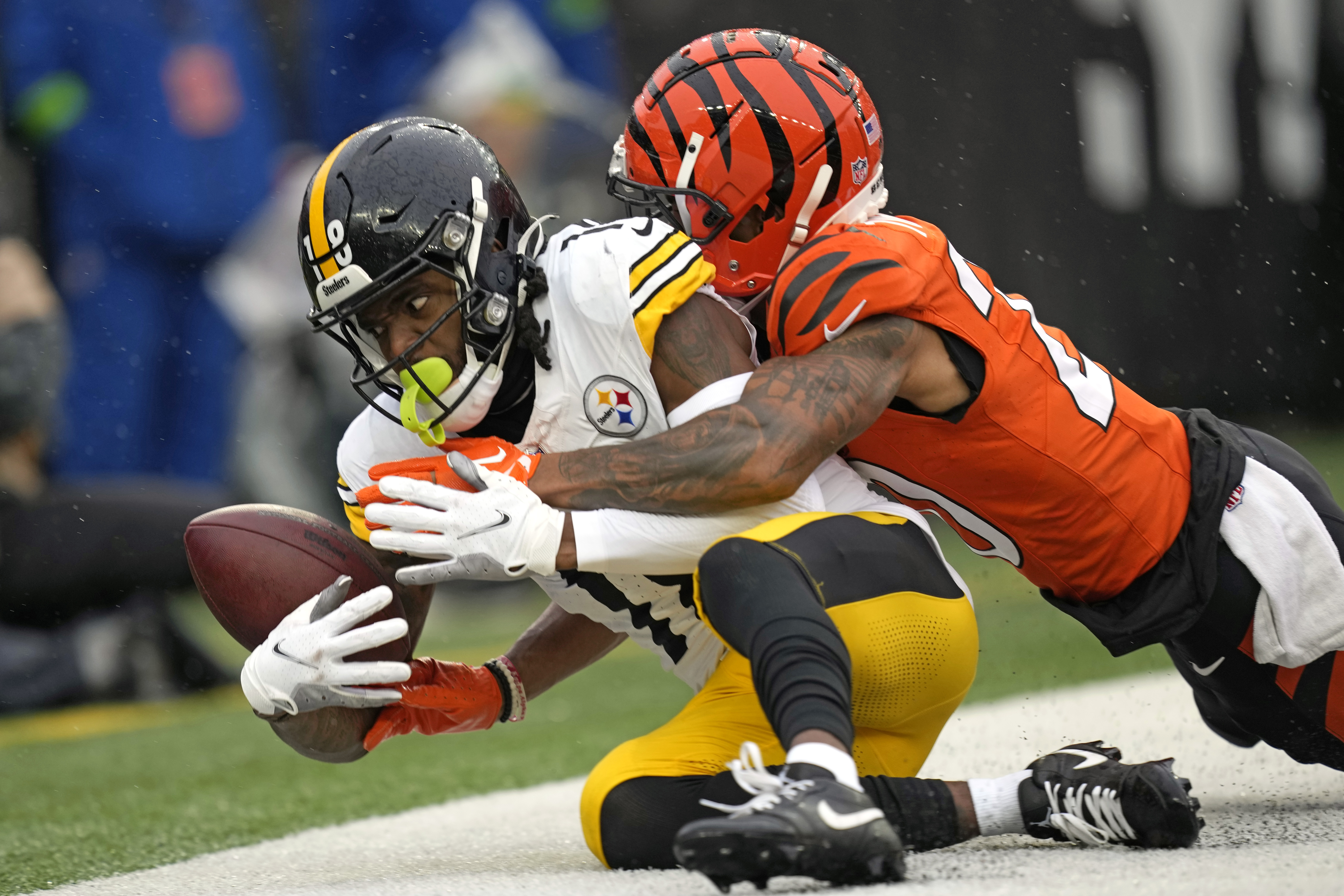 Pittsburgh Steelers wide receiver Diontae Johnson (18) can't hang onto the ball as he falls out of the end zone with Cincinnati Bengals cornerback DJ Turner II (20) defending during the first half of an NFL football game in Cincinnati, Sunday, Nov. 26, 2023. There was no touchdown on the play.