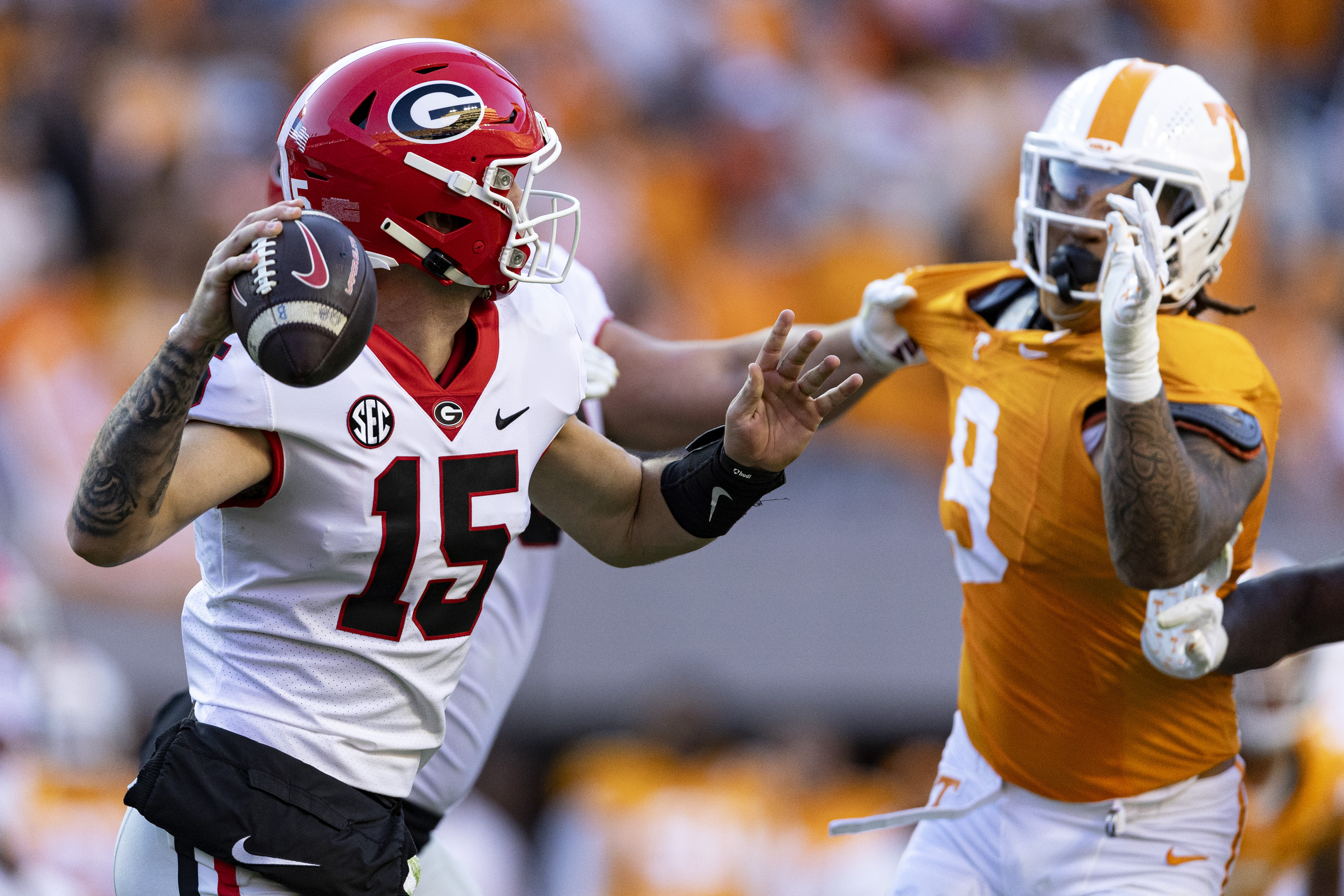 Georgia quarterback Carson Beck (15) throws to a receiver as he's pressured by Tennessee defensive back Brandon Turnage (8) during the first half of an NCAA college football game Saturday, Nov. 18, 2023, in Knoxville, Tenn.