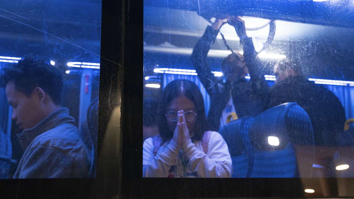 Thai nationals gesture from a bus as they leave the Shamir Hospital in Ramle, Israel, Wednesday, on their way back to Thailand, after being released from Hamas custody.