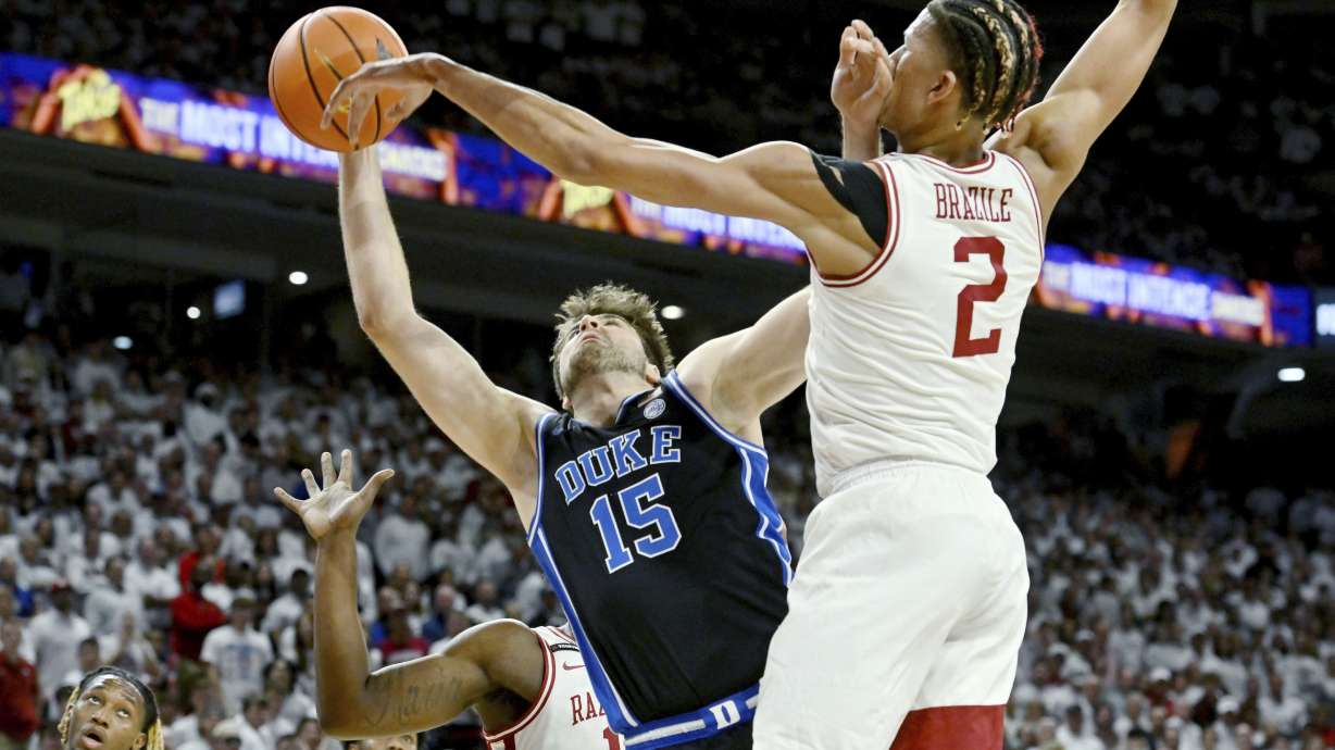 Duke center Ryan Young (15) is fouled as he tries to drive past Arkansas forward Trevon Brazile (2) during the first half of an NCAA college basketball game Wednesday, Nov. 29, 2023, in Fayetteville, Ark.