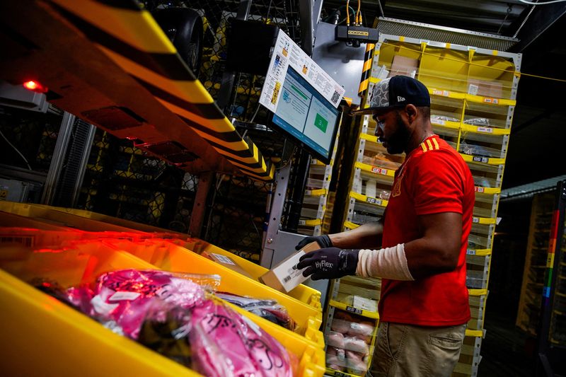 A worker selects and packs items during Cyber Monday at the Amazon fulfillment center in Robbinsville Township in New Jersey, Tuesday.