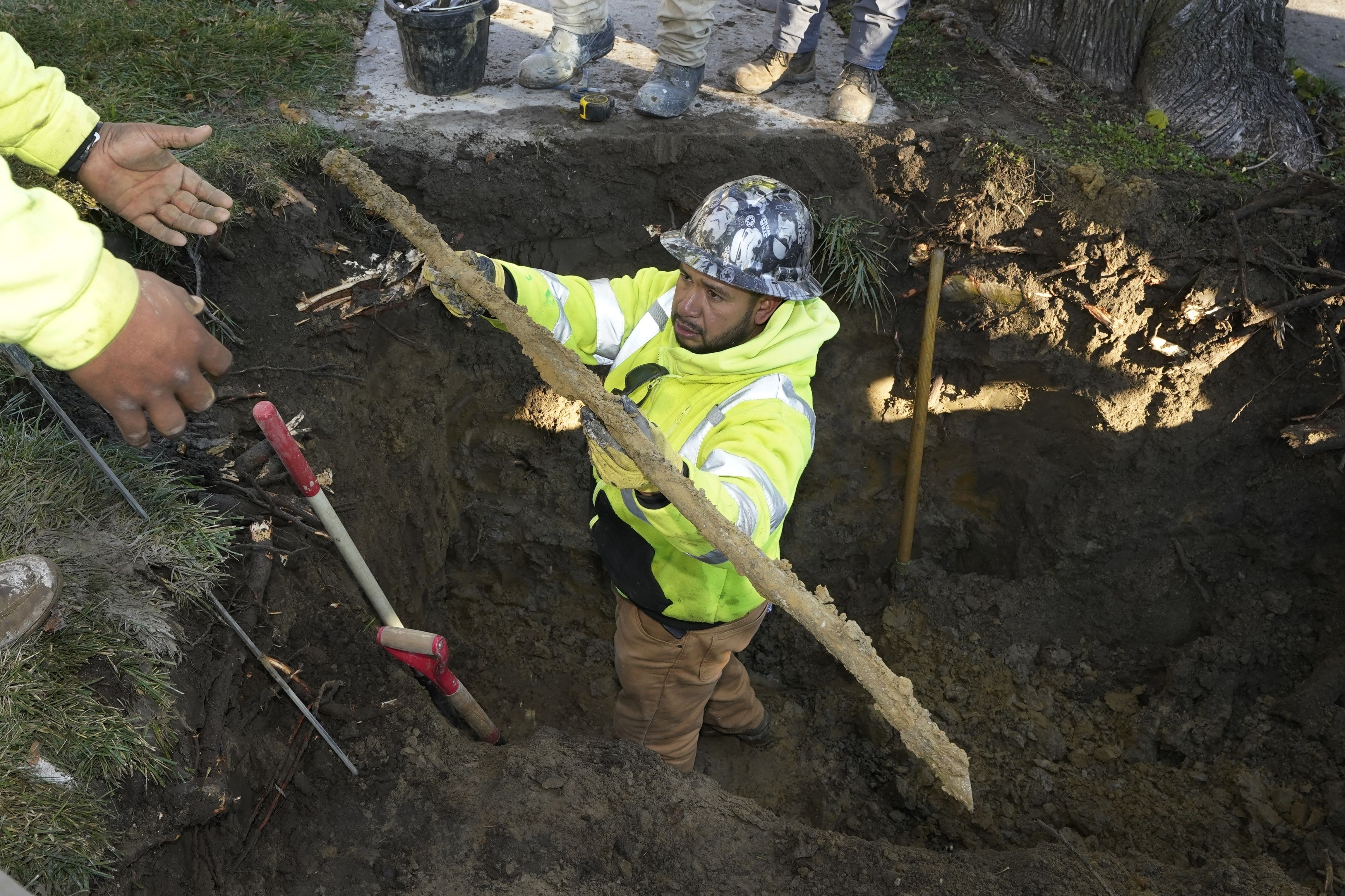 A cut lead pipe is pulled from a dig site for testing at a home in Royal Oak, Mich., on Nov. 16, 2021. The Environmental Protection Agency is proposing a plan to replace all lead pipes in the nation’s water system over the next 10 years..