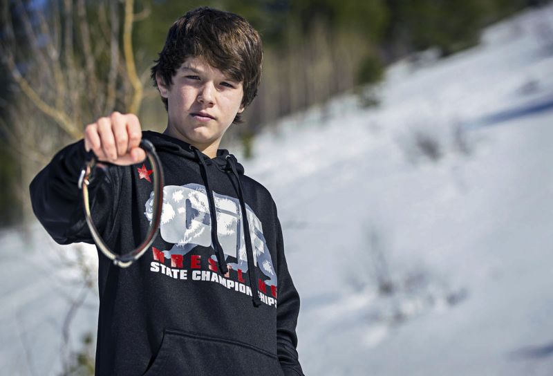 In this March 17, 2017, photo, Canyon Mansfield holds the collar of his dog, Casey, who was killed March 16 by a cyanide-ejecting device placed on public land by federal workers to kill coyotes near his home in Pocatello, Idaho.