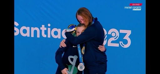Chloe Cederholm, an Olympus Jr. High seventh grader, receives a hug from fellow Team USA member Taylor Winnett, during the medal ceremony for the women's 100 meter backstroke event at the Santiago 2023 Parapan American Games in November.