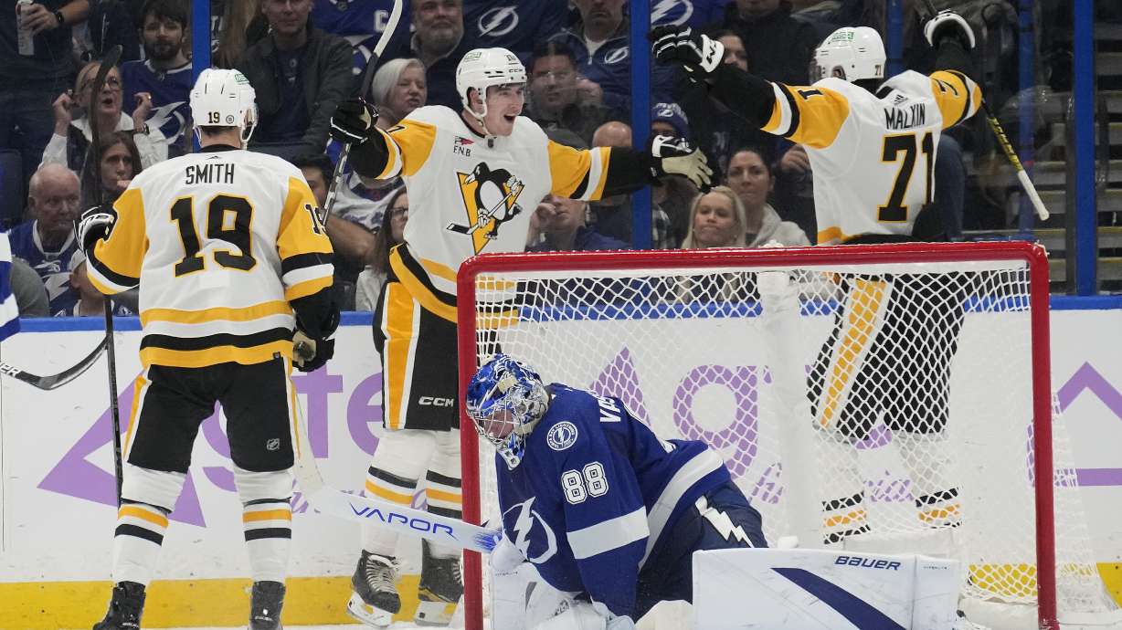 Pittsburgh Penguins left wing Drew O'Connor (10) celebrates with center Evgeni Malkin (71) and =right wing Reilly Smith (19) after scoring past Tampa Bay Lightning goaltender Andrei Vasilevskiy (88) during the second period of an NHL hockey game Thursday, Nov. 30, 2023, in Tampa, Fla.