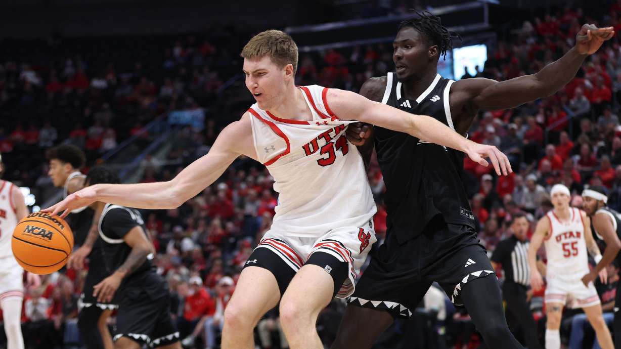 Utah Utes center Lawson Lovering (34) is defended by Hawaii Warriors center Mor Seck (23) at the Delta Center in Salt Lake City on Thursday, Nov. 30, 2023.