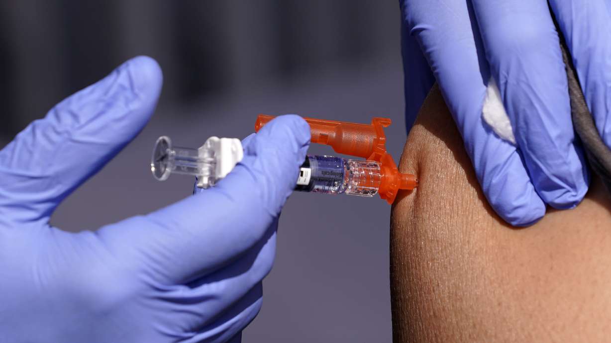 A patient is given a flu vaccine Oct. 28, 2022, in Lynwood, Calif. Seasonal flu continues to pick up steam in the U.S. But among respiratory viruses, COVID-19 remains the main cause of hospitalizations and deaths, health officials said Friday.