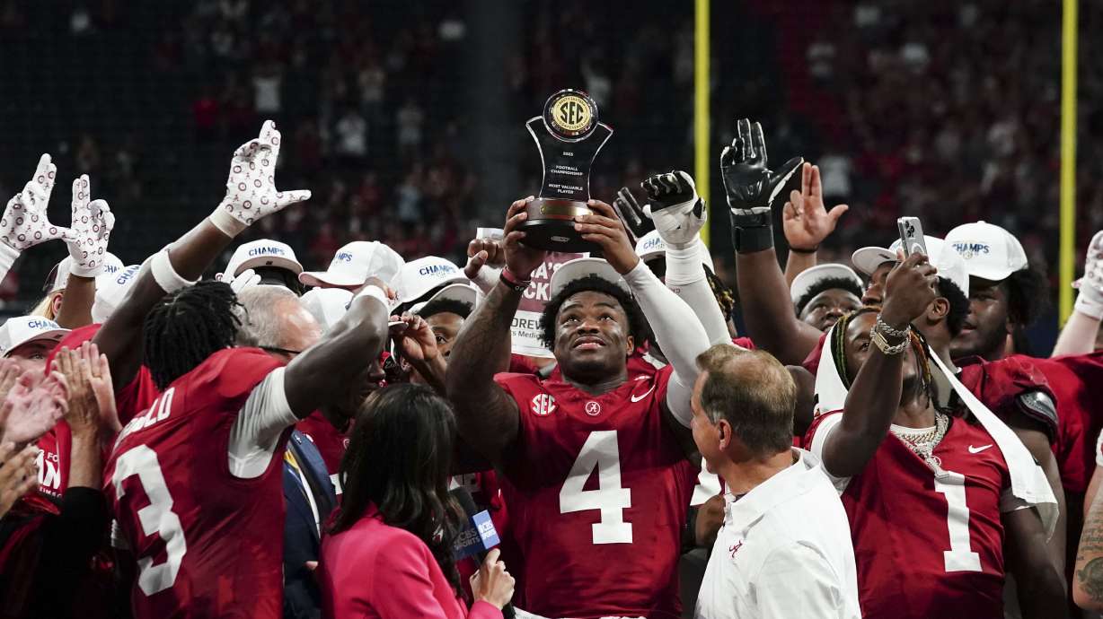 Alabama quarterback Jalen Milroe (4) holds up the MVP trophy after the Southeastern Conference championship NCAA college football game against Georgia in Atlanta, Saturday, Dec. 2, 2023.