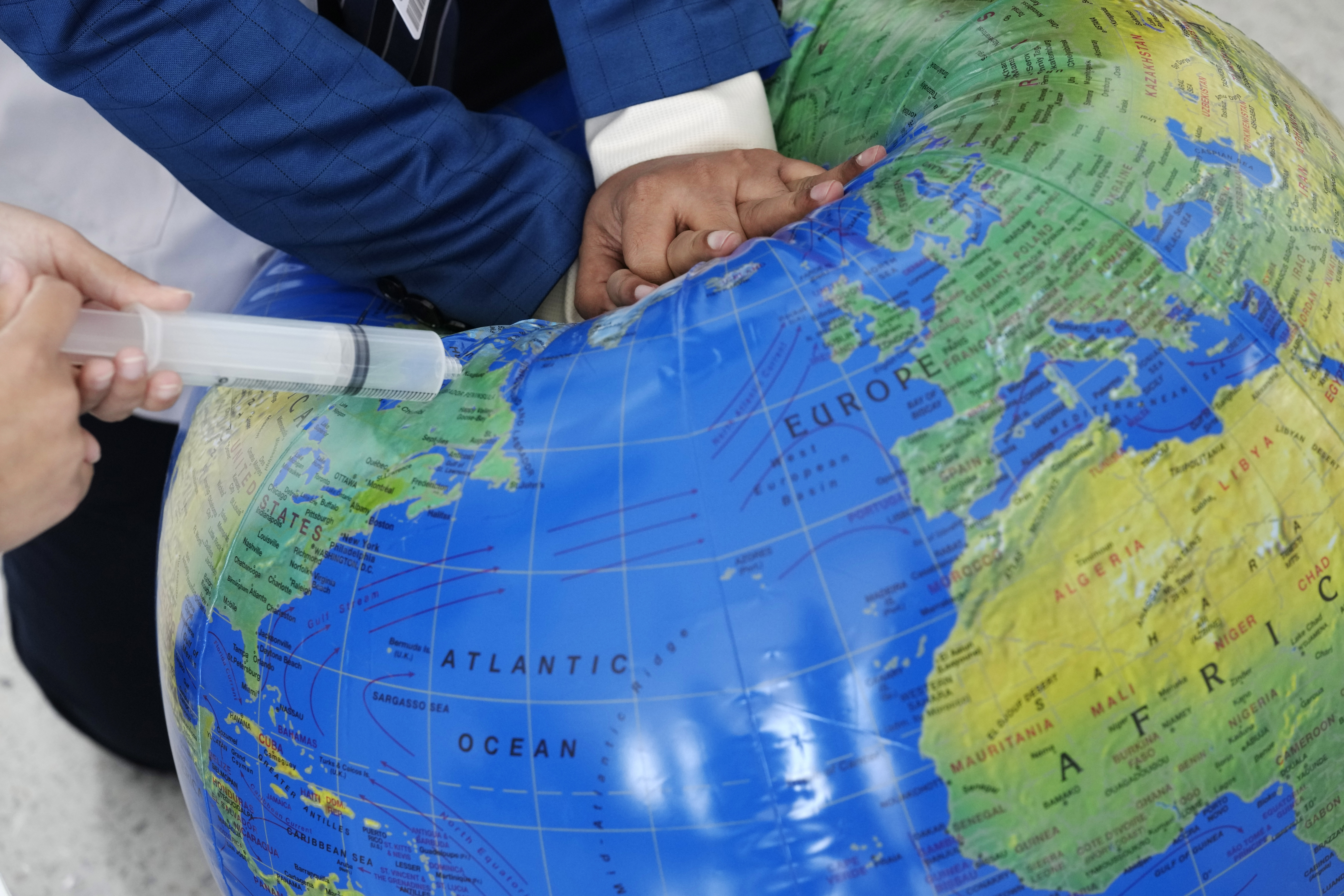 People pretend to resuscitate the Earth during a demonstration at the COP28 U.N. Climate Summit, Sunday, in Dubai, United Arab Emirates.