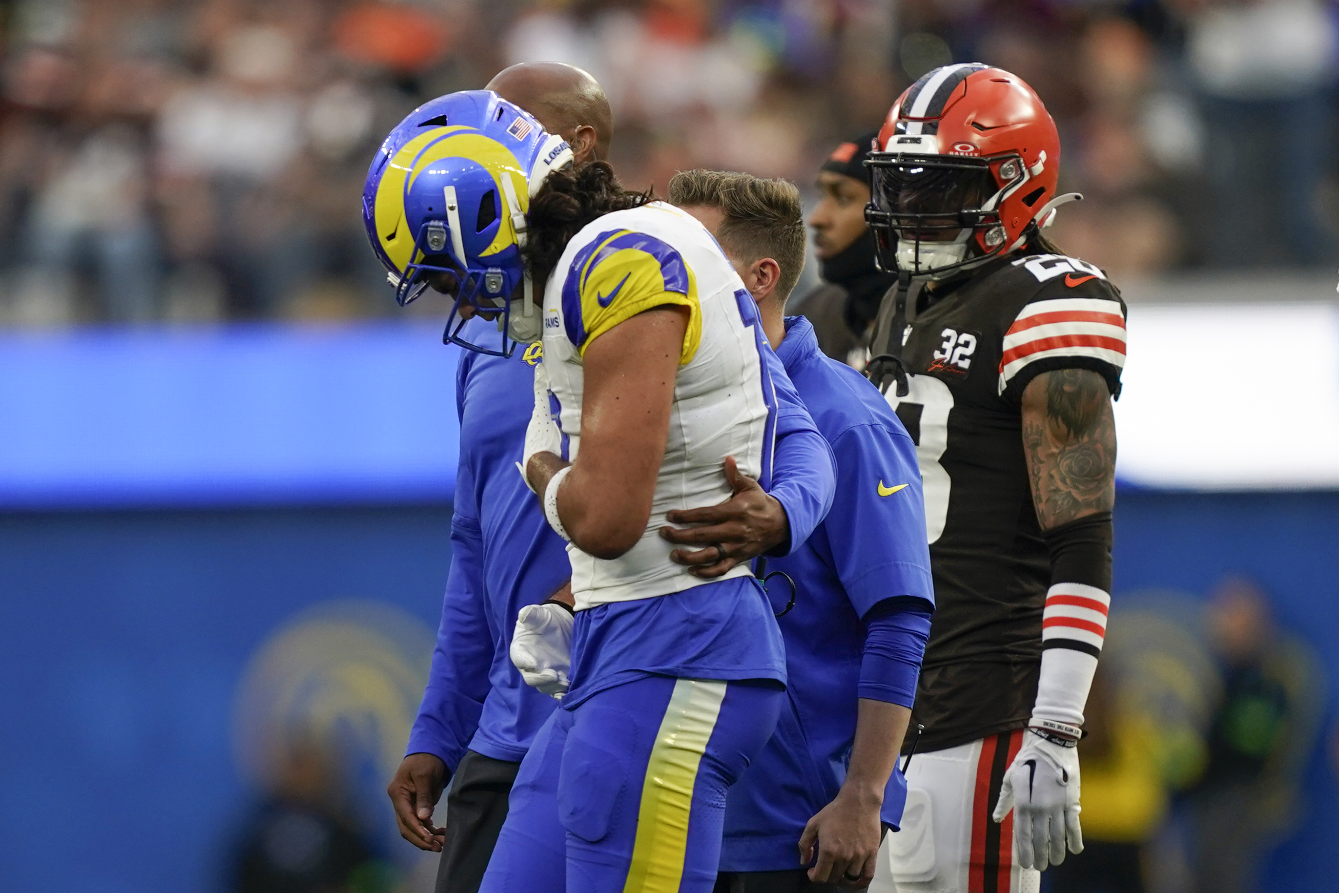 Los Angeles Rams wide receiver Puka Nacua, center front, is helped off the field after an injury during the first half of an NFL football game against the Cleveland Browns, Sunday, Dec. 3, 2023, in Inglewood, Calif.