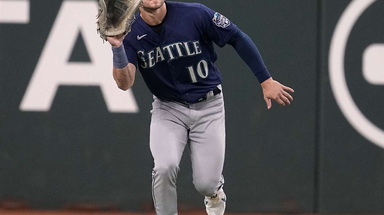 FILE - Seattle Mariners left fielder Jarred Kelenic reaches up to catch a flyout by Texas Rangers' Nathaniel Lowe in the first inning of a baseball game, Sept. 24, 2023, in Arlington, Texas. The Atlanta Braves acquired Kelenic, pitcher Marco Gonzales and infielder Evan White from the Mariners, Sunday, Dec. 3, 2023, for right-handed pitchers Cole Phillips and Jackson Kowar.