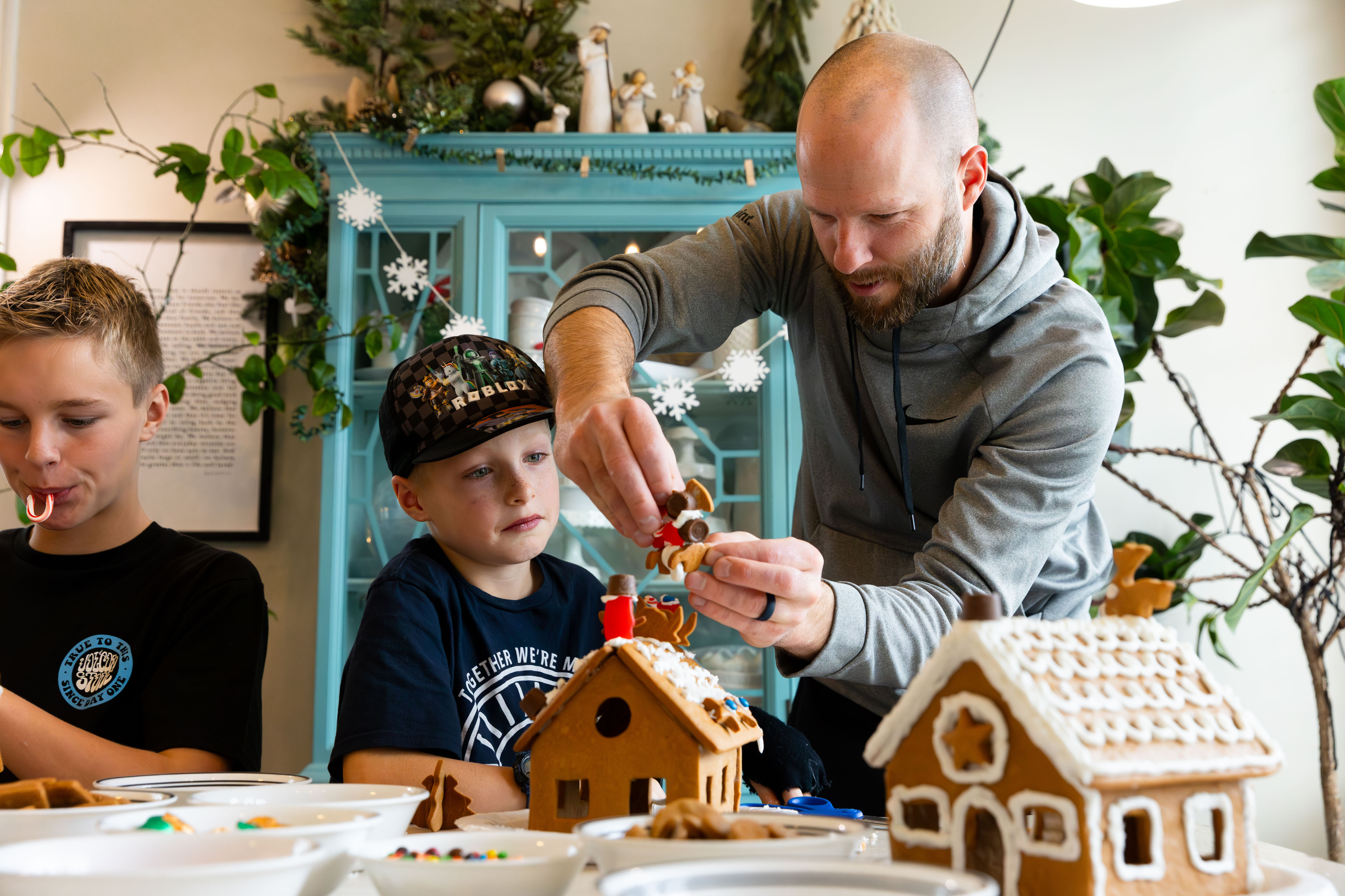 Darin Priday, right, helps his son Zeke, 8, rebuild his fallen gingerbread house at their home in Saratoga Springs on Sunday.