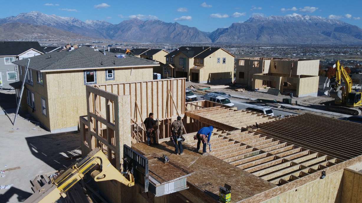Workers construct single-family homes in Saratoga Springs Nov. 14. Utah gained close to 56,000 new residents from July 2022 to July 1 of this year, according to a report published Wednesday.