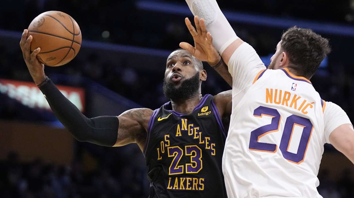Los Angeles Lakers forward LeBron James, left, shoots as Phoenix Suns center Jusuf Nurkic defends during the first half of an NBA basketball In-Season Tournament quarterfinal game Tuesday, Dec. 5, 2023, in Los Angeles.